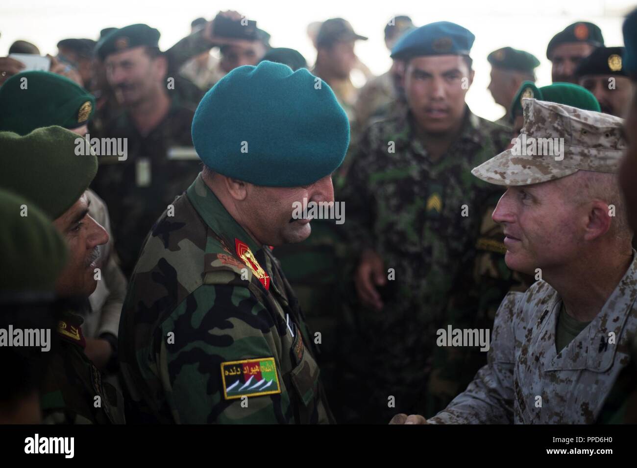 HELMAND PROVINCE, Afghanistan (August 30, 2018) - Afghan Maj. Gen. Wali Mohammad Ahmadzai, former commanding general of the Afghan National Army (ANA) 215th Corps, says goodbye to U.S. Marine Corps Col. Edward J. Headley, Task Force-Southwest’s senior advisor to the ANA 215th Corps prior to boarding a flight. Ahmadzai relinquished command of the ANA 215th Corps to Afghan Brig. Gen. Abdul Hadi Tarin and assumed command of the 209th “Shaheen” Corps. Stock Photo