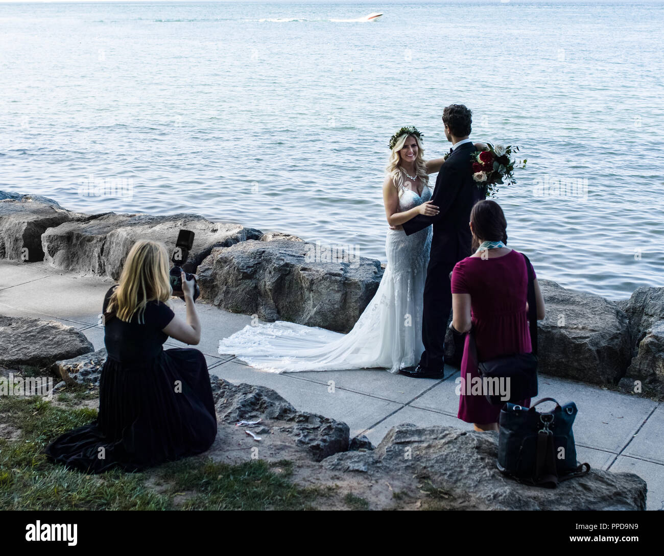 A couple is getting married at Niagara On The Lake, a photographer and her assistant are also present. Stock Photo