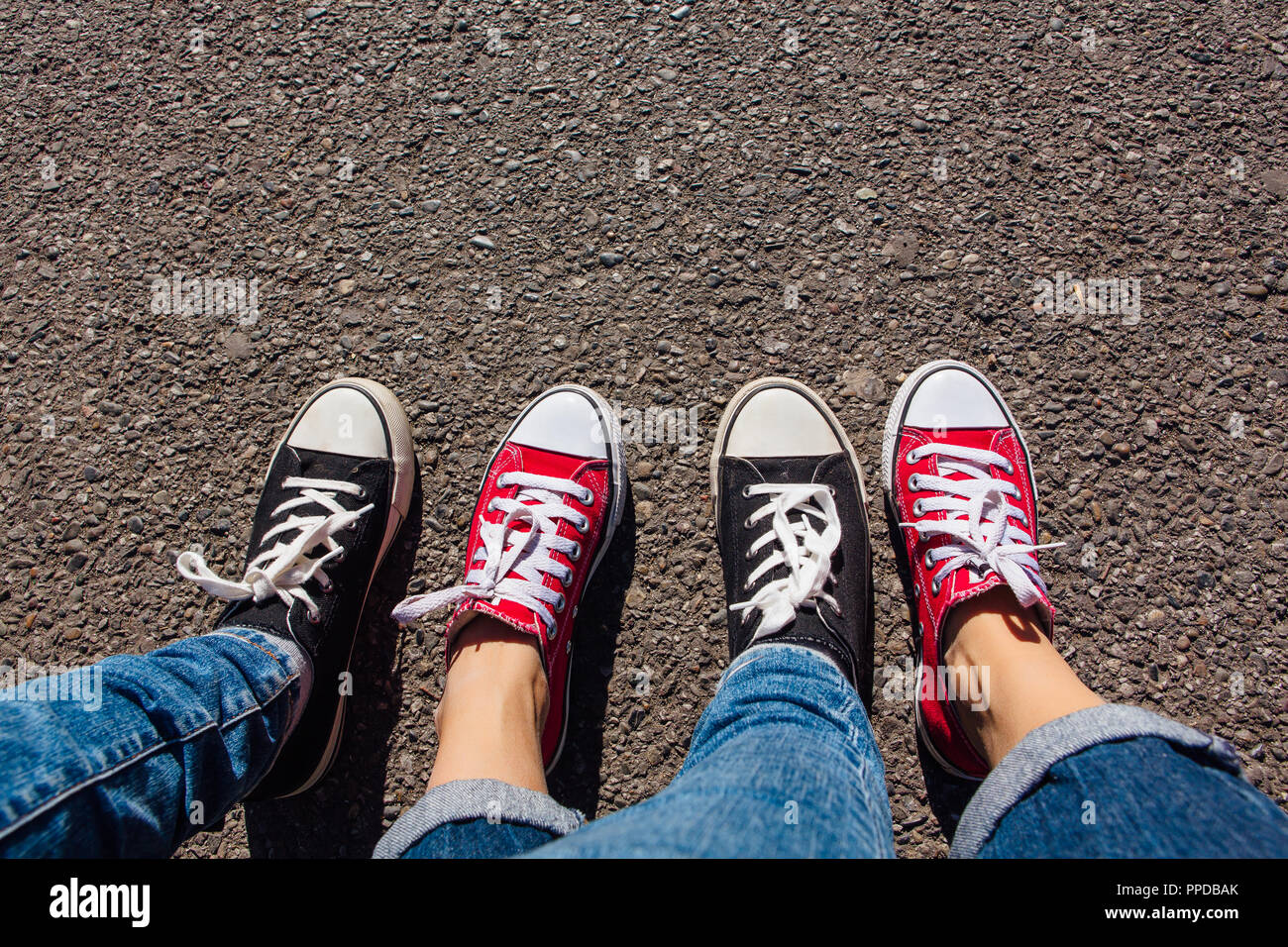 Red and black sneakers shoes on women's feet. Sneakers shoes Couple. Copy  space Stock Photo - Alamy