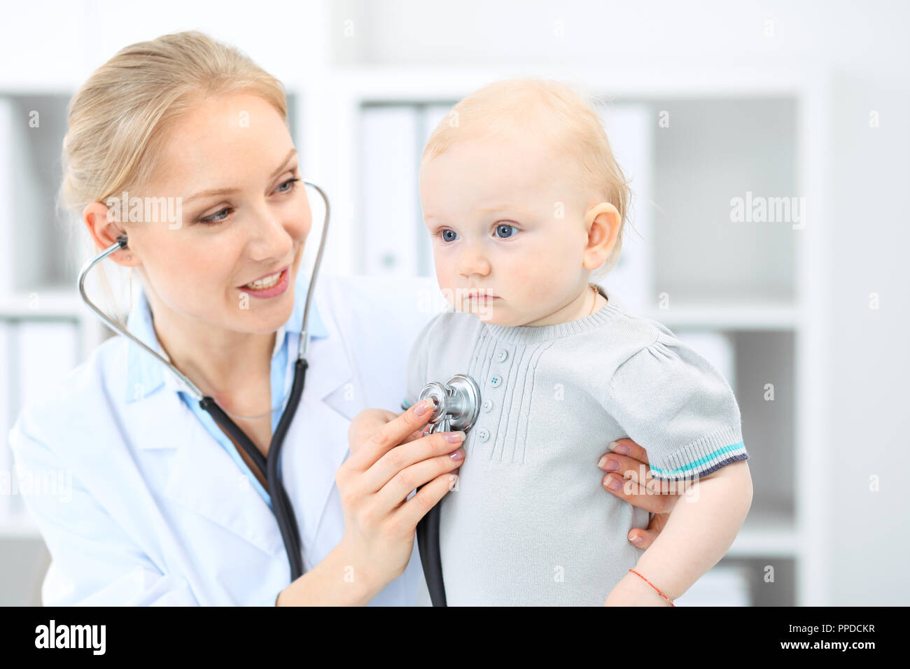 Doctor and patient in hospital. Little girl is being examined by pediatrician with stethoscope. Medicine and health care Stock Photo