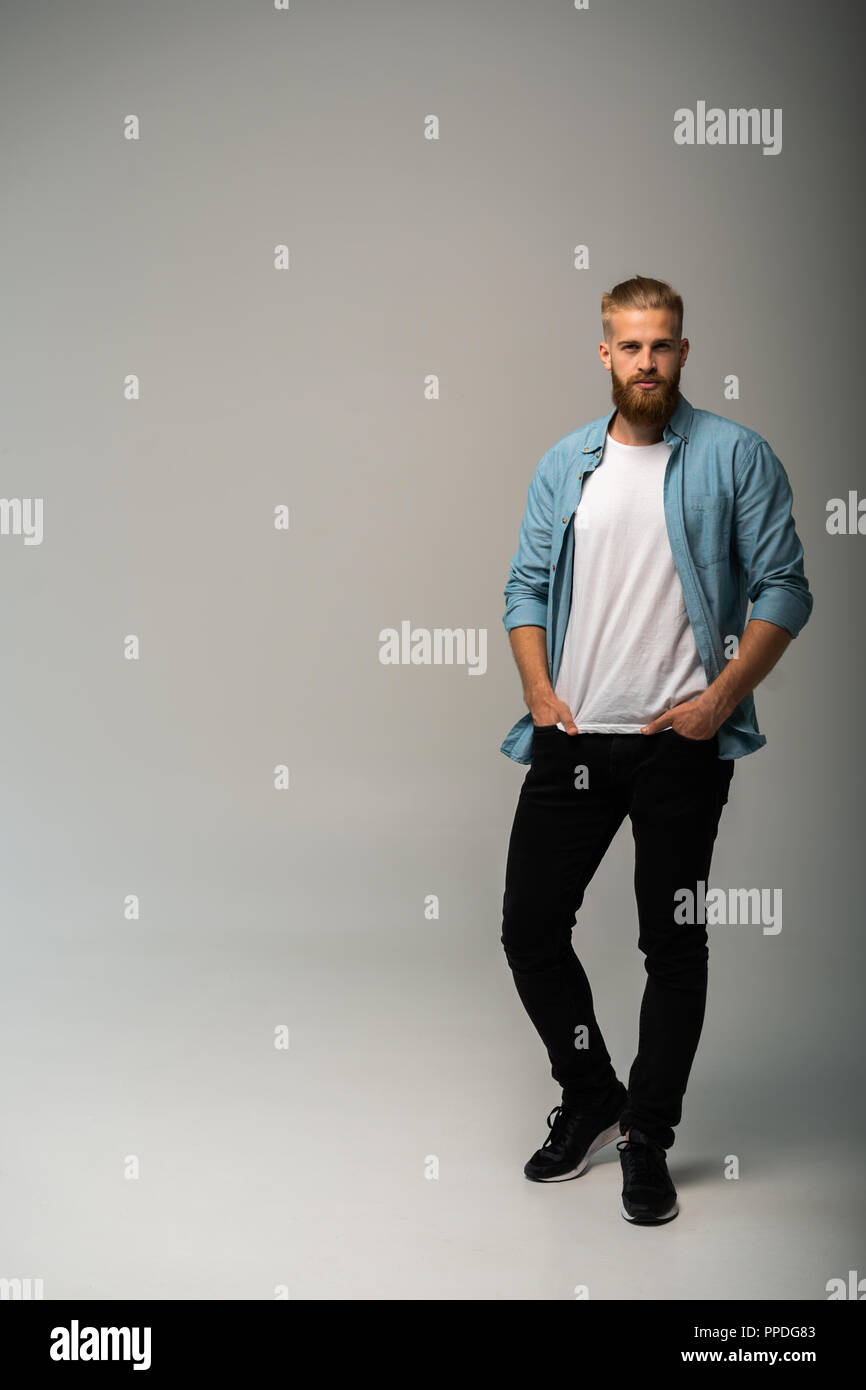 Full length portrait of a happy casual man standing isolated on a gray ...