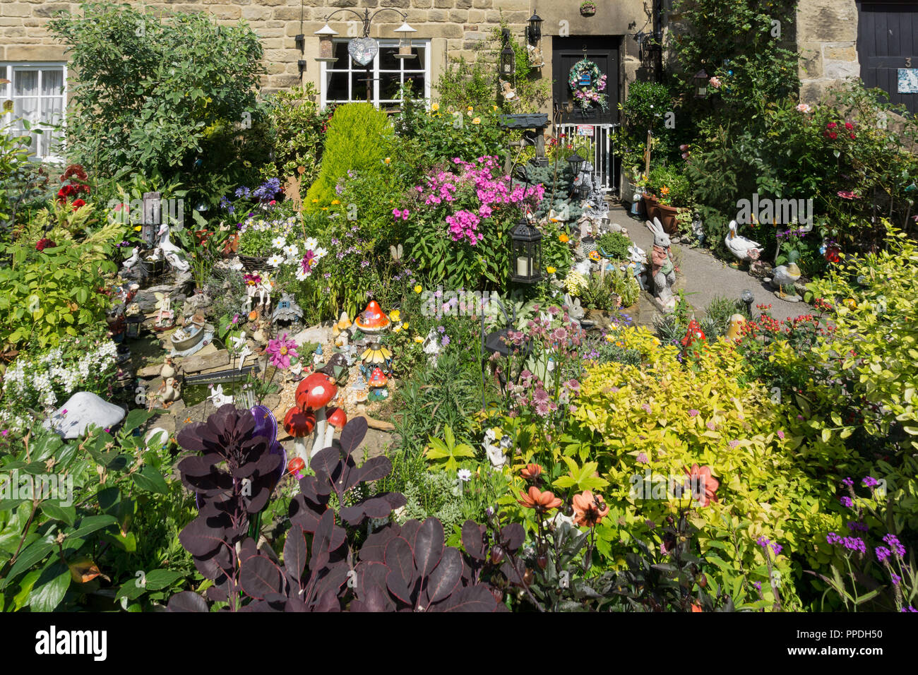 Colourful cottage garden in Summer in one of the so called Plague Cottages, Eyam, Derbyshire, UK Stock Photo
