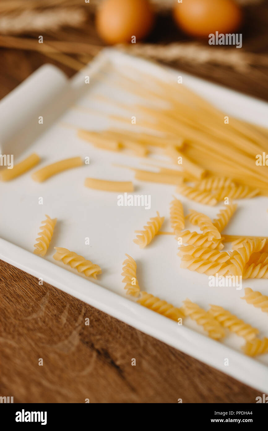 Raw pasta on the rustic wooden background. Selective focus Stock Photo