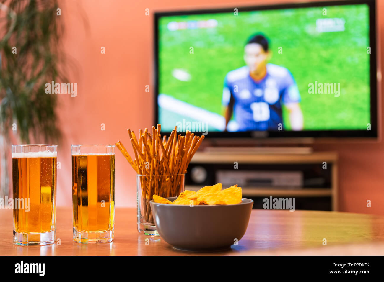 Watching football or soccer on television with beer, chips and