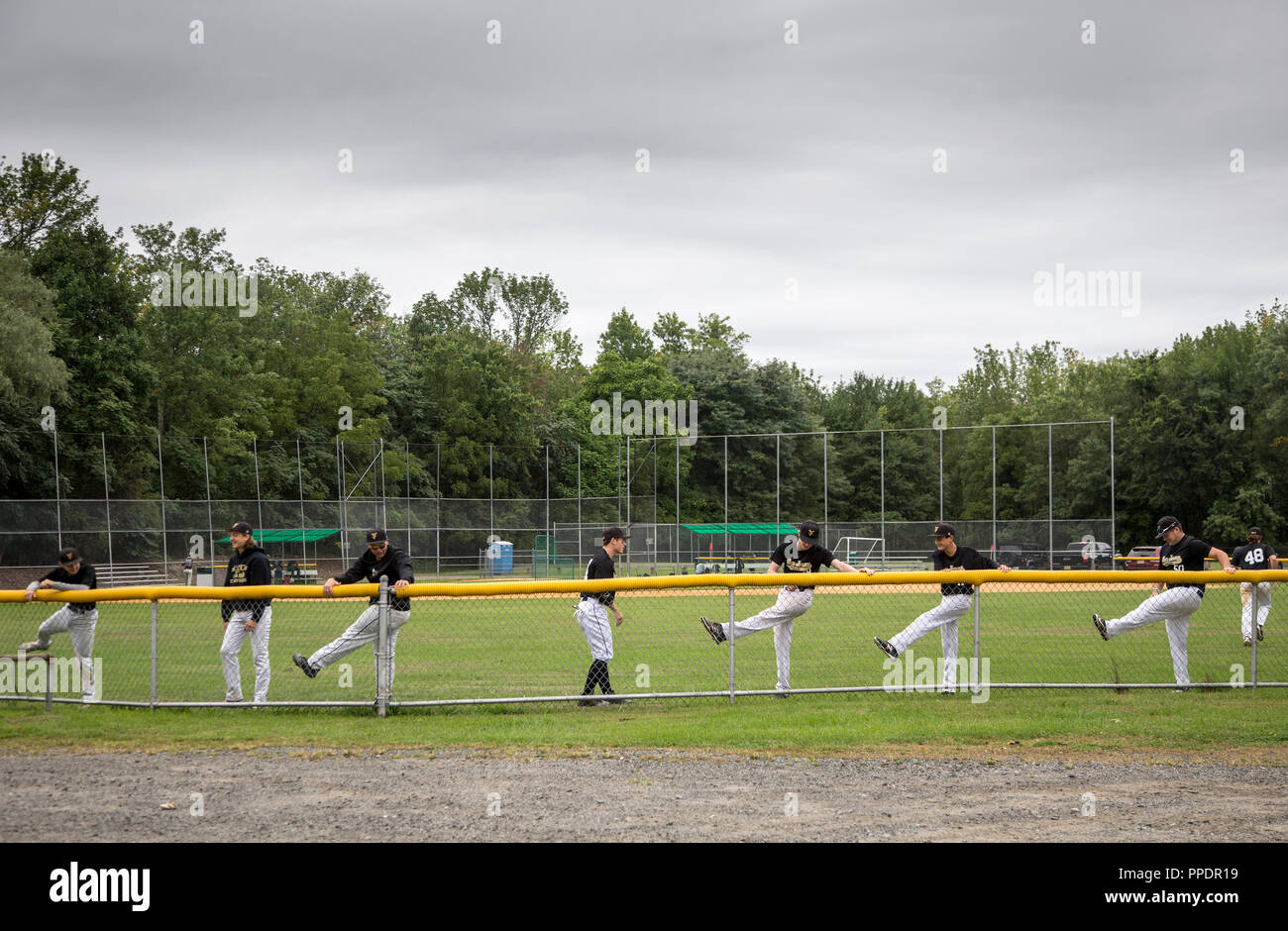 Teenage baseball players stretching before a ball game Stock Photo