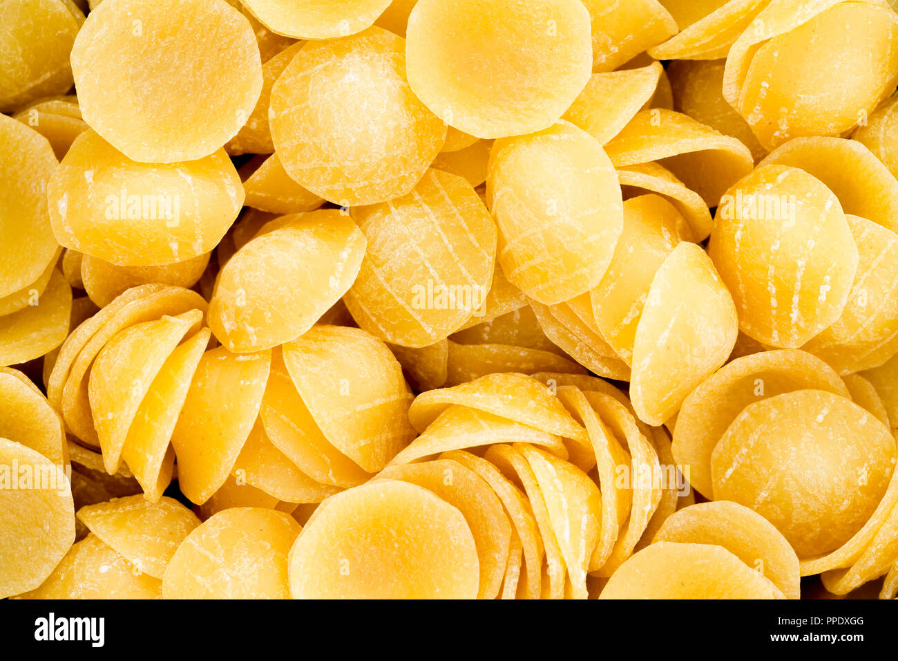 Close up full frame texture of fresh orecchiette Italian pasta shaped like concave discs or ears and a speciality noodle from the Apulia region of Ita Stock Photo