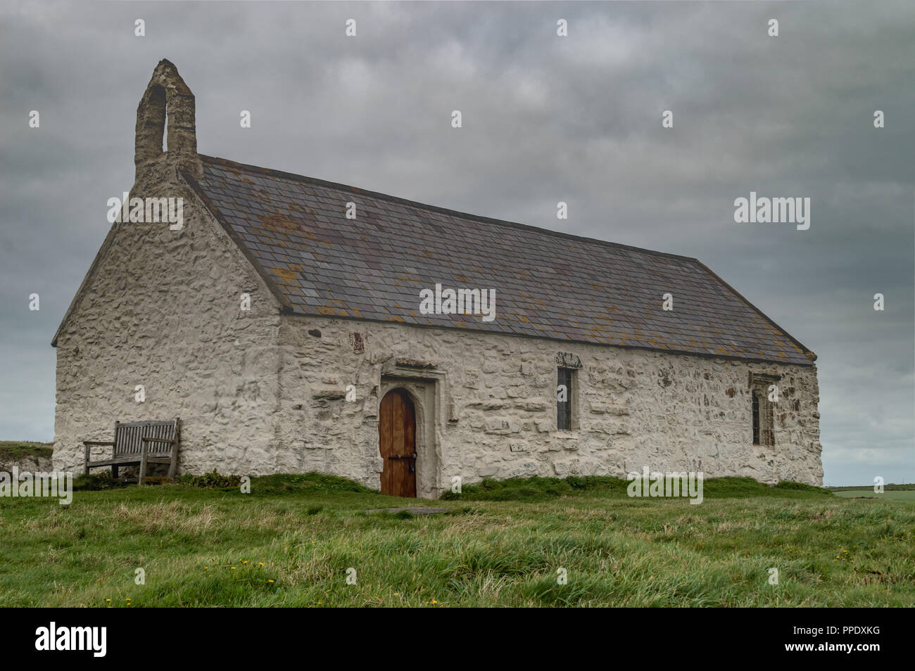 The 12th century St Cwyfan Church, on the small tidal island of Cribinauon, on Anglesey. Stock Photo