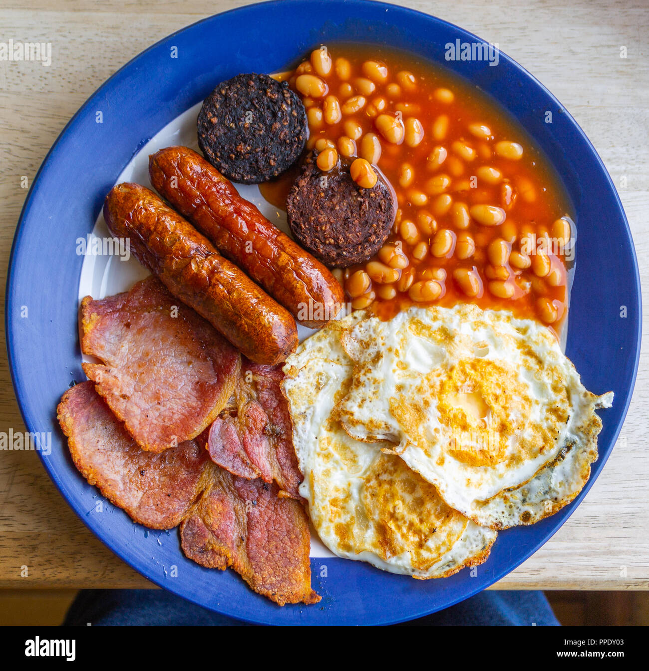 overhead view of a full english fried breakfast of eggs bacon beans and