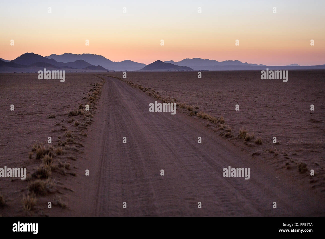 Empty road through desert, african wilderness at twilight Stock Photo