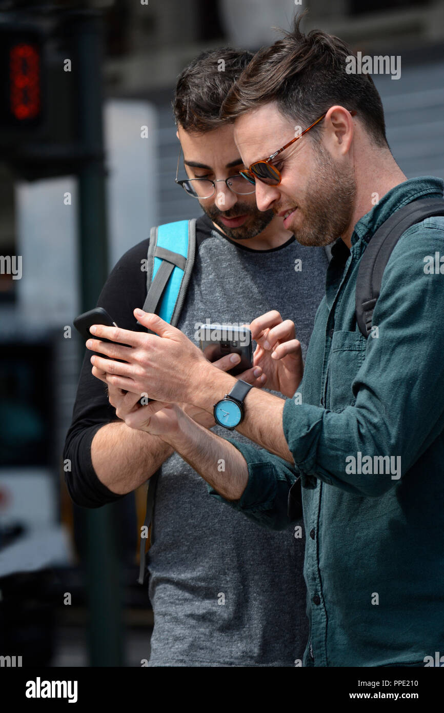 Two young men use their smartphones Stock Photo Alamy