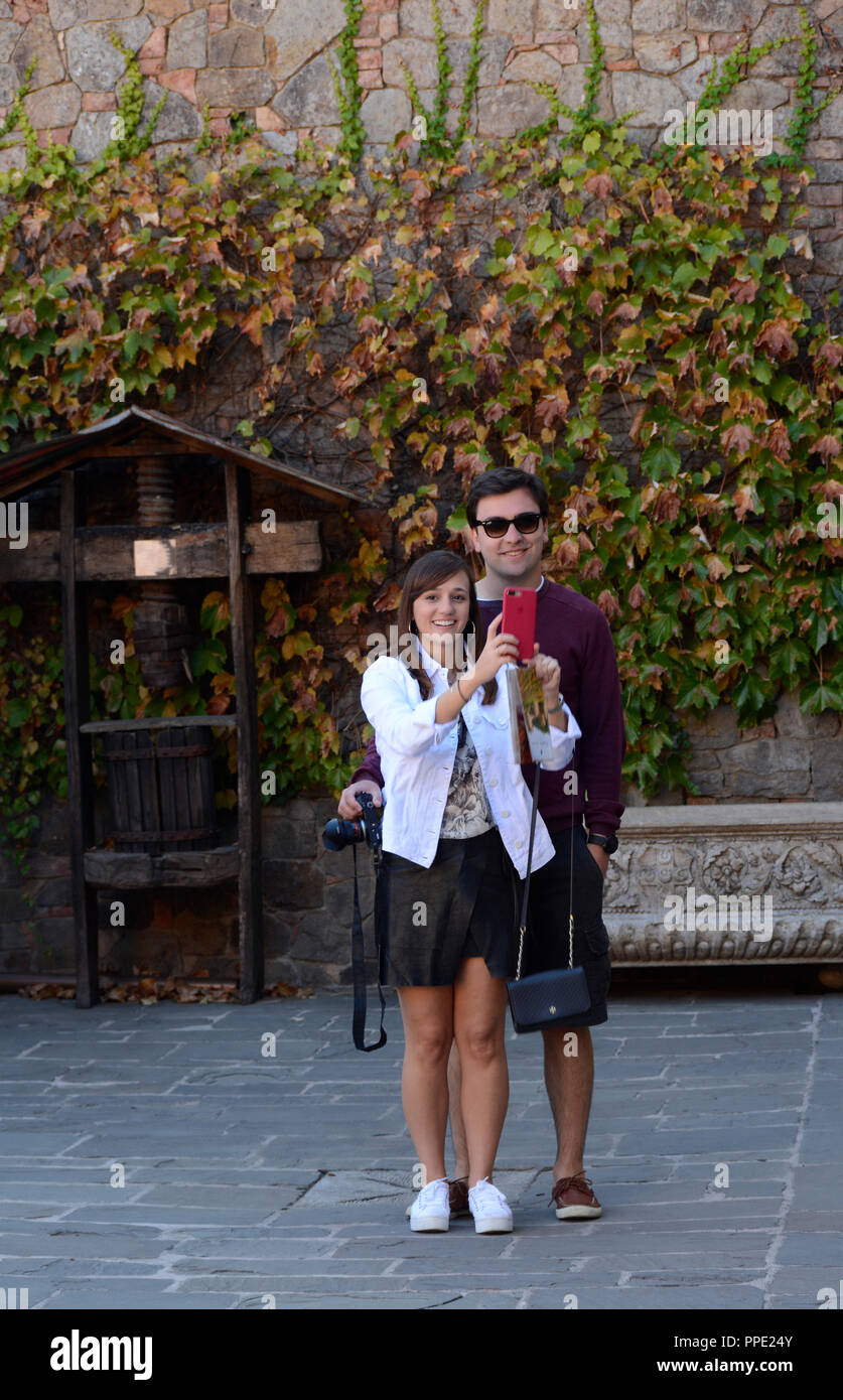 A young couple vacationing in California take a ‘selfie’ photograph with a smartphone at Castello di Amorosa Winery Stock Photo