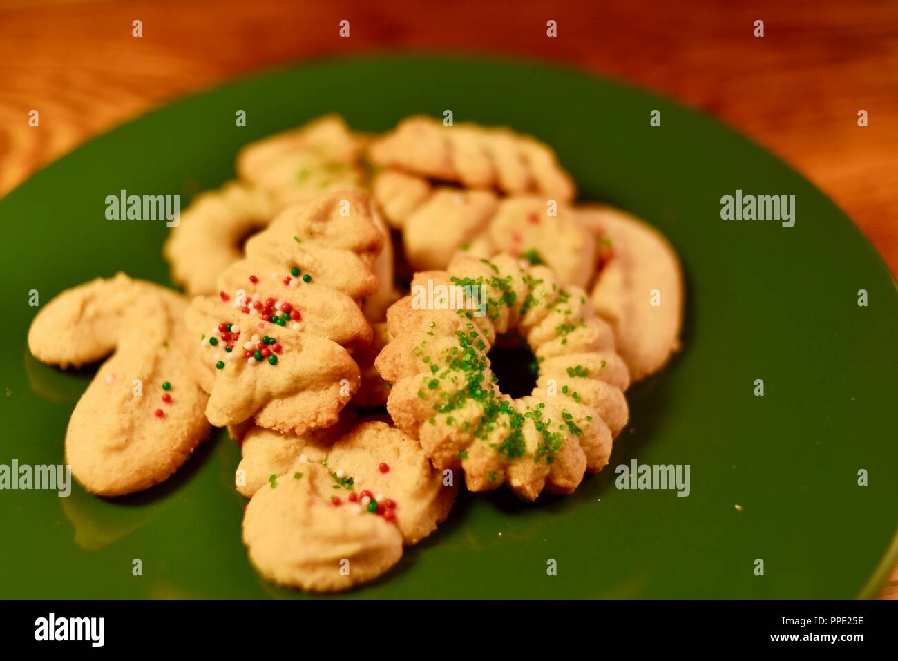 Homemade, home baked and hand decorated holiday Christmas Spritz sugar cookies with sprinkles, shaped in wreaths and trees, Wisconsin, USA Stock Photo