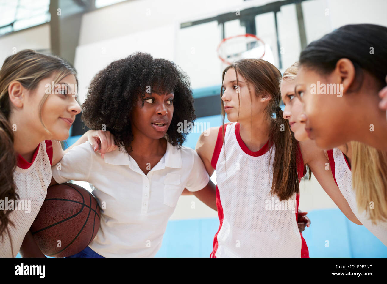 Female High School Basketball Players In Huddle Having Team Talk With