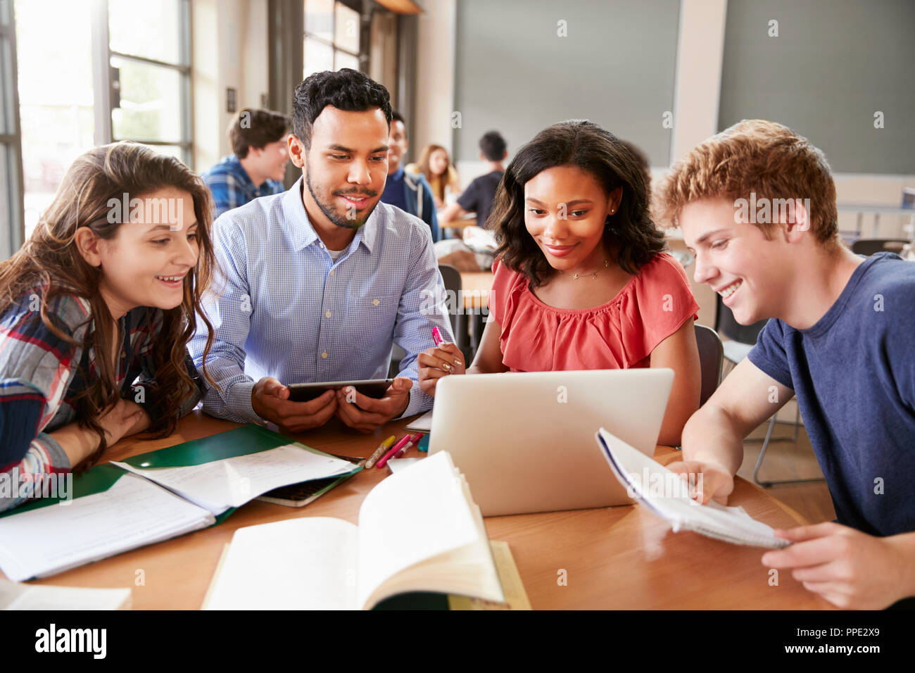 High School Students Using Laptops And Digital Tablets Working With ...