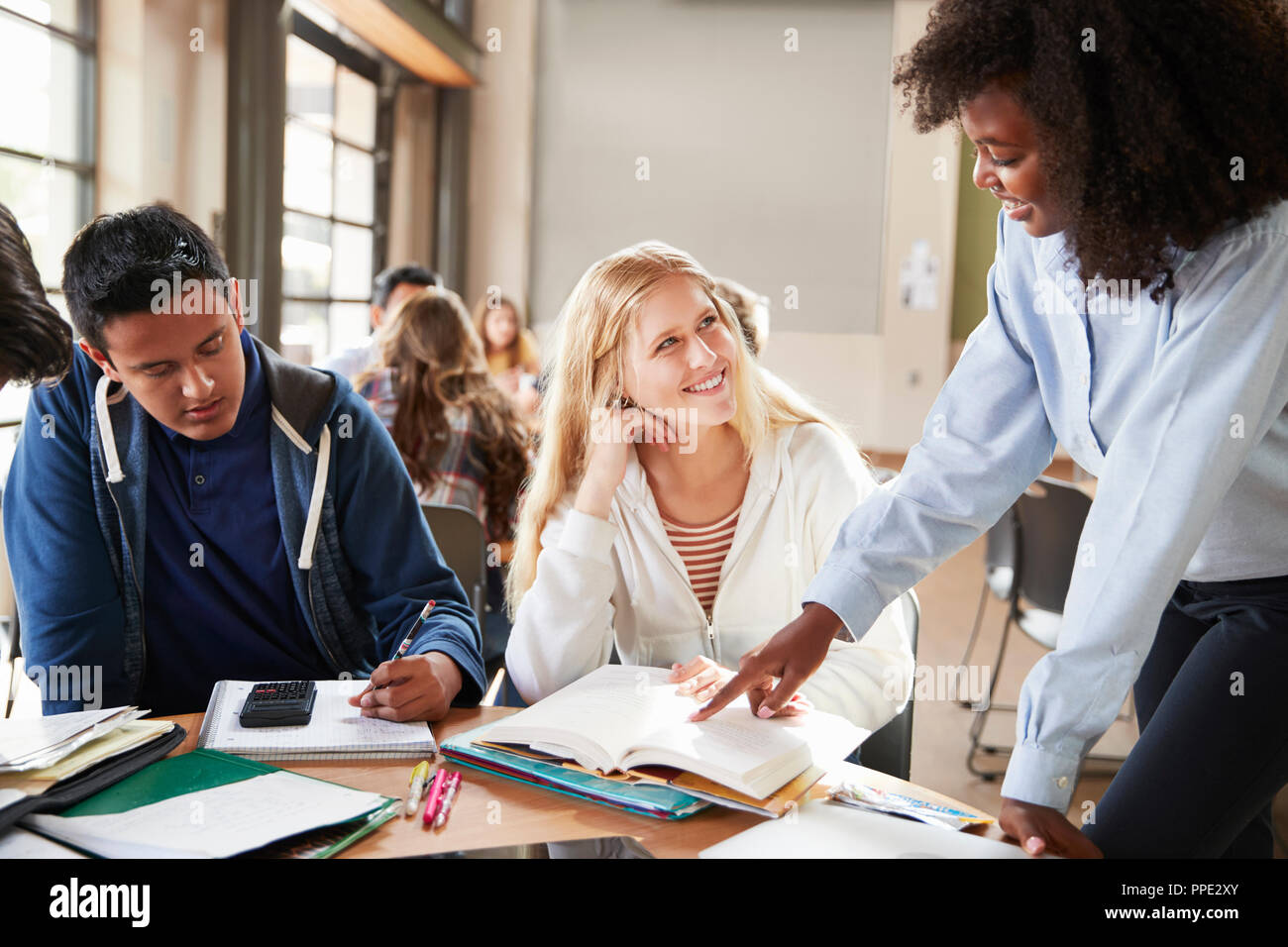 Group Of High School Students With Female Teacher Working At Desk Stock ...