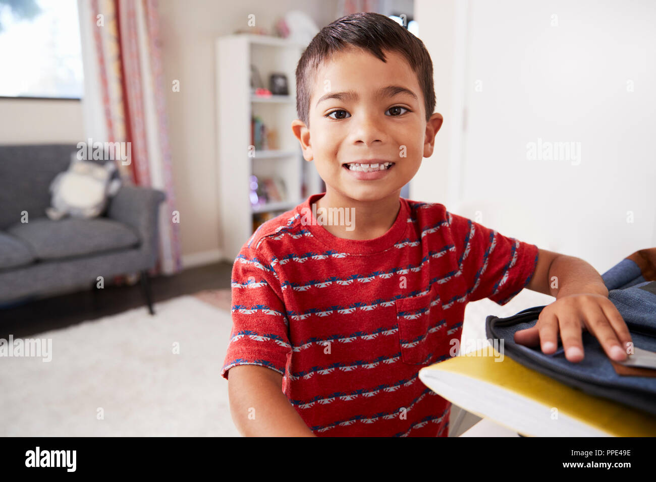 Portrait Of Boy In Bedroom Packing Bag Ready For School Stock Photo