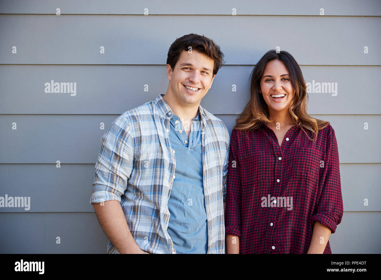 Portrait Of Couple Standing Outside Grey Clapboard House Stock Photo ...