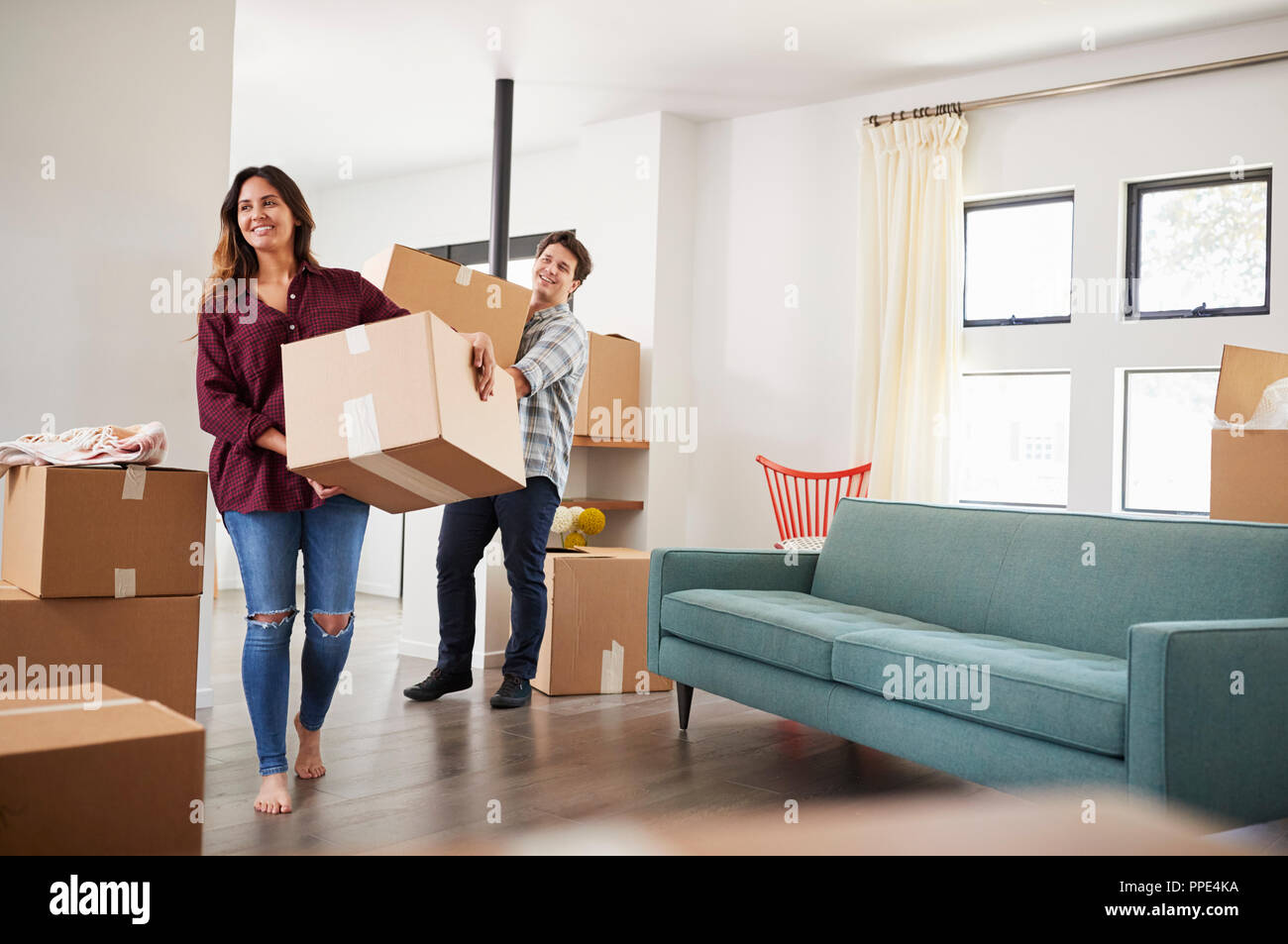 Excited Couple Carrying Boxes Into New Home On Moving Day Stock Photo ...