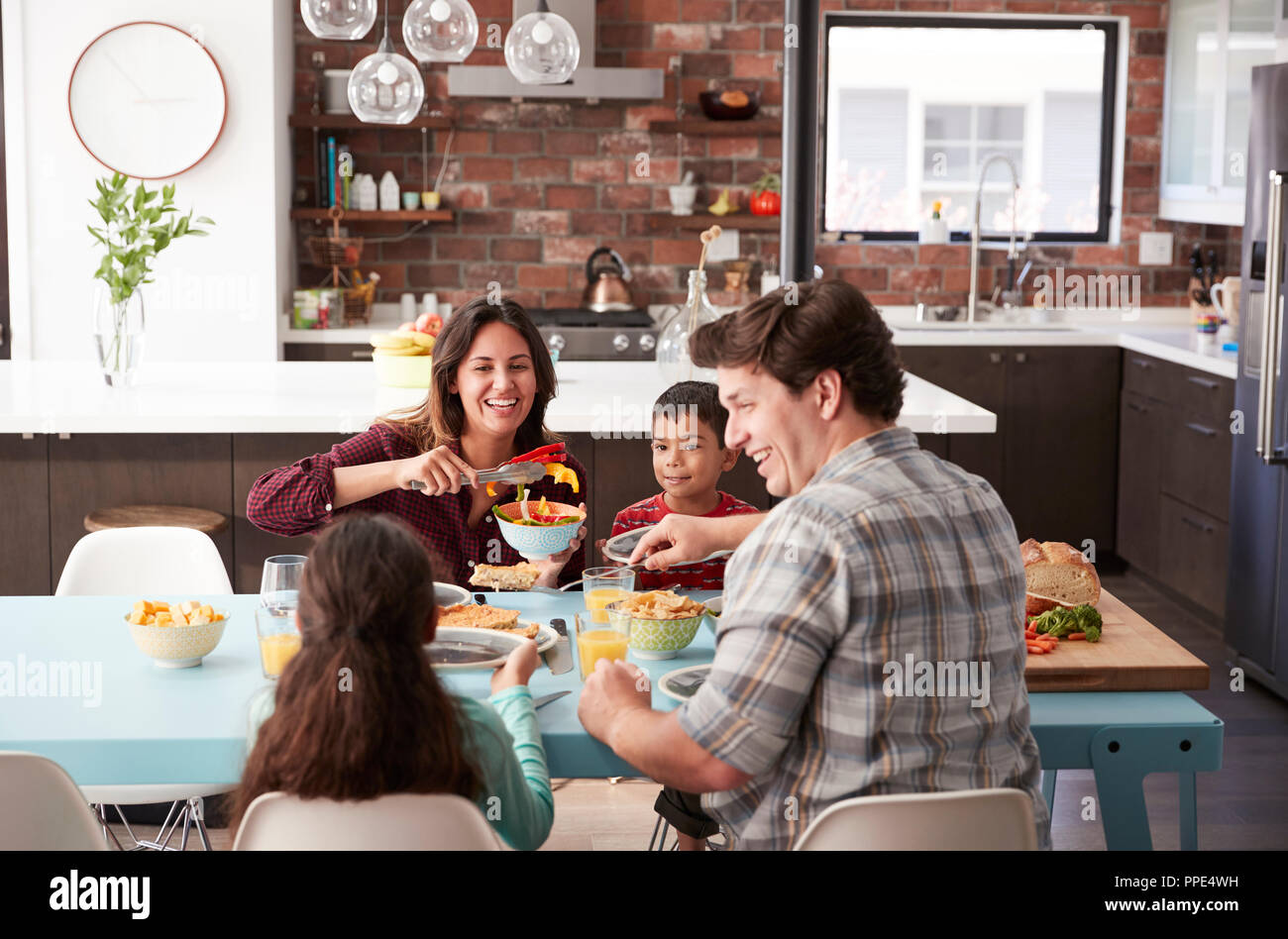 Family Enjoying Meal Around Table At Home Together Stock Photo