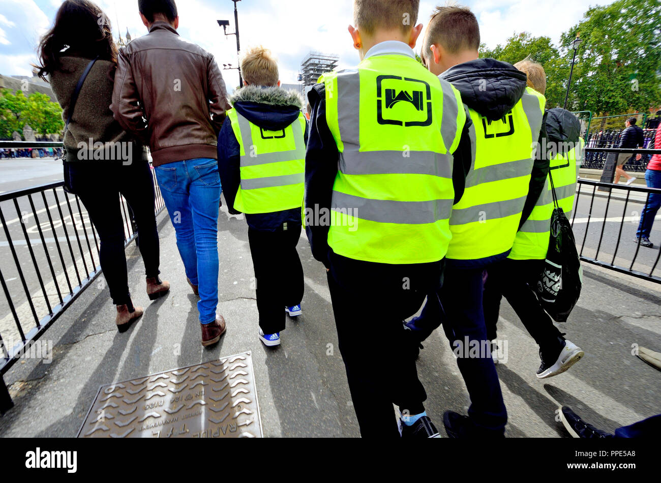 Schoolchildren in hi-vis vests on a school trip, Parliament Square, London, England, UK. Stock Photo