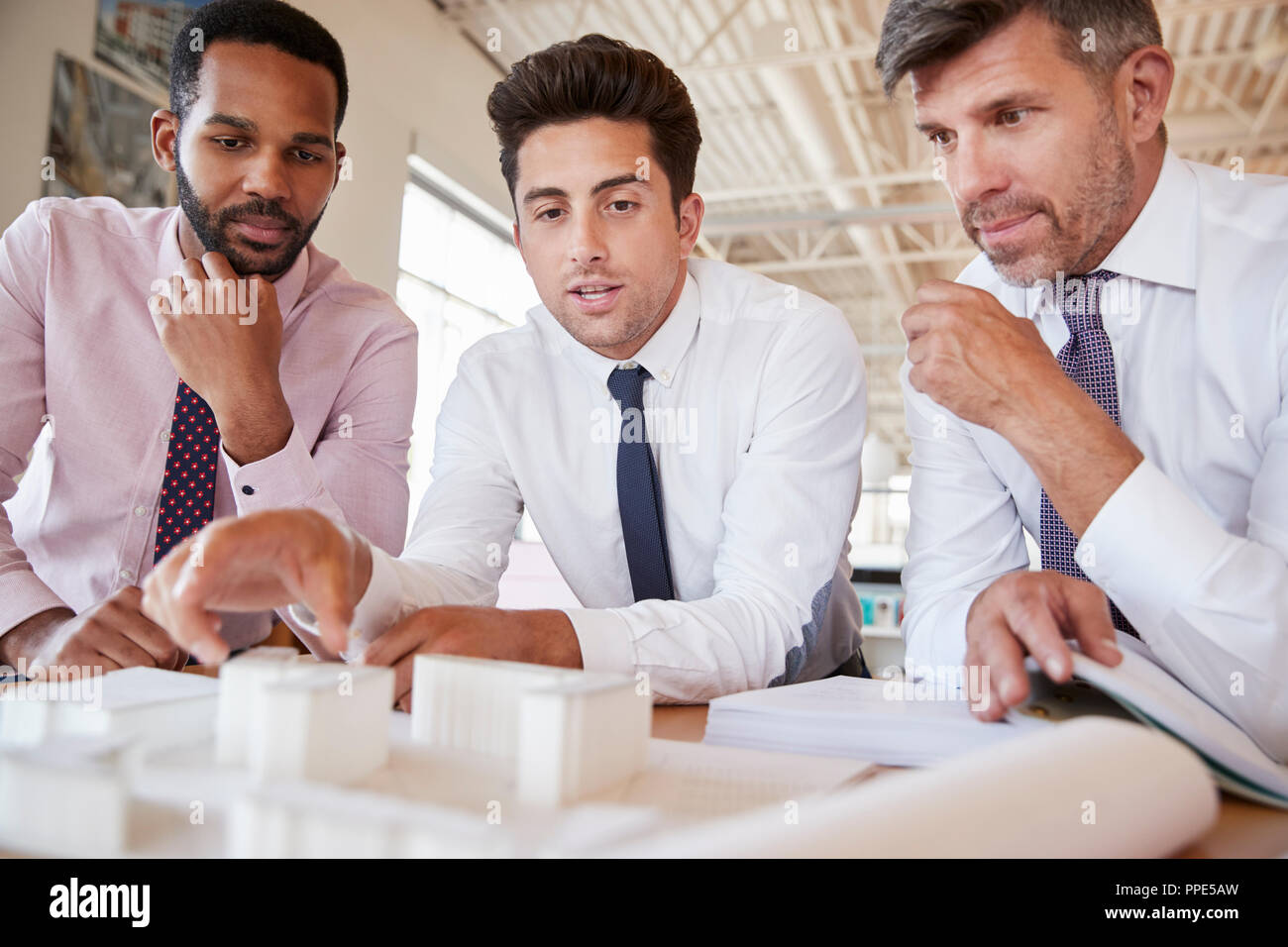 Three male colleagues discussing an architectural model Stock Photo