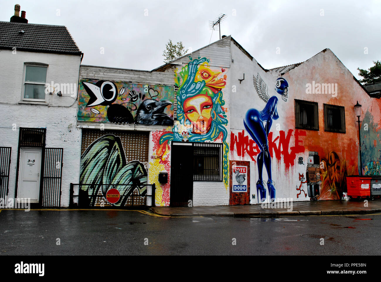 LONDON STREET ART ADORNS AN EX GARAGE NOW ART GALLERY ON A WET DAY IN WEST LONDON. Stock Photo