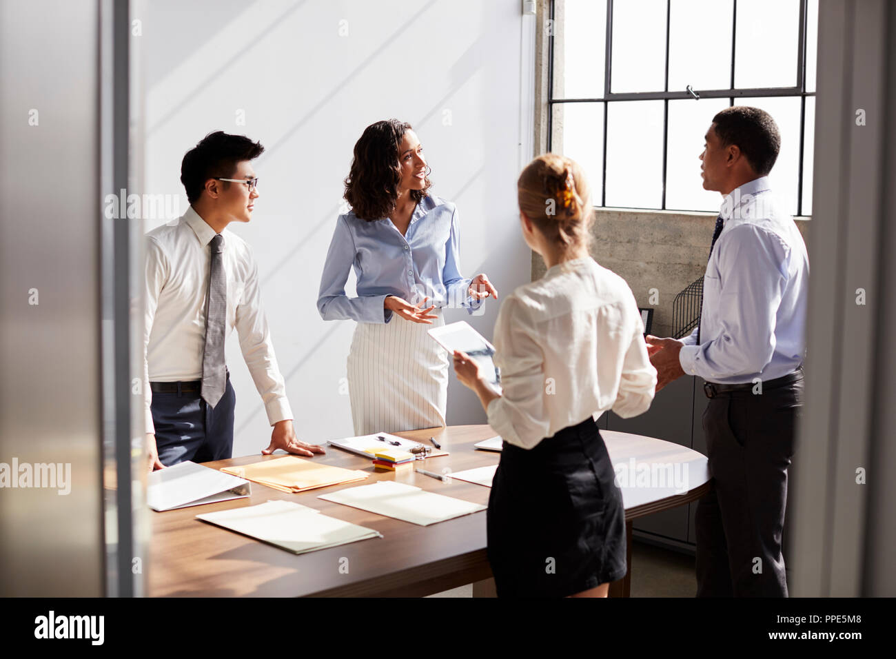 Four business colleagues working together in a small office Stock Photo