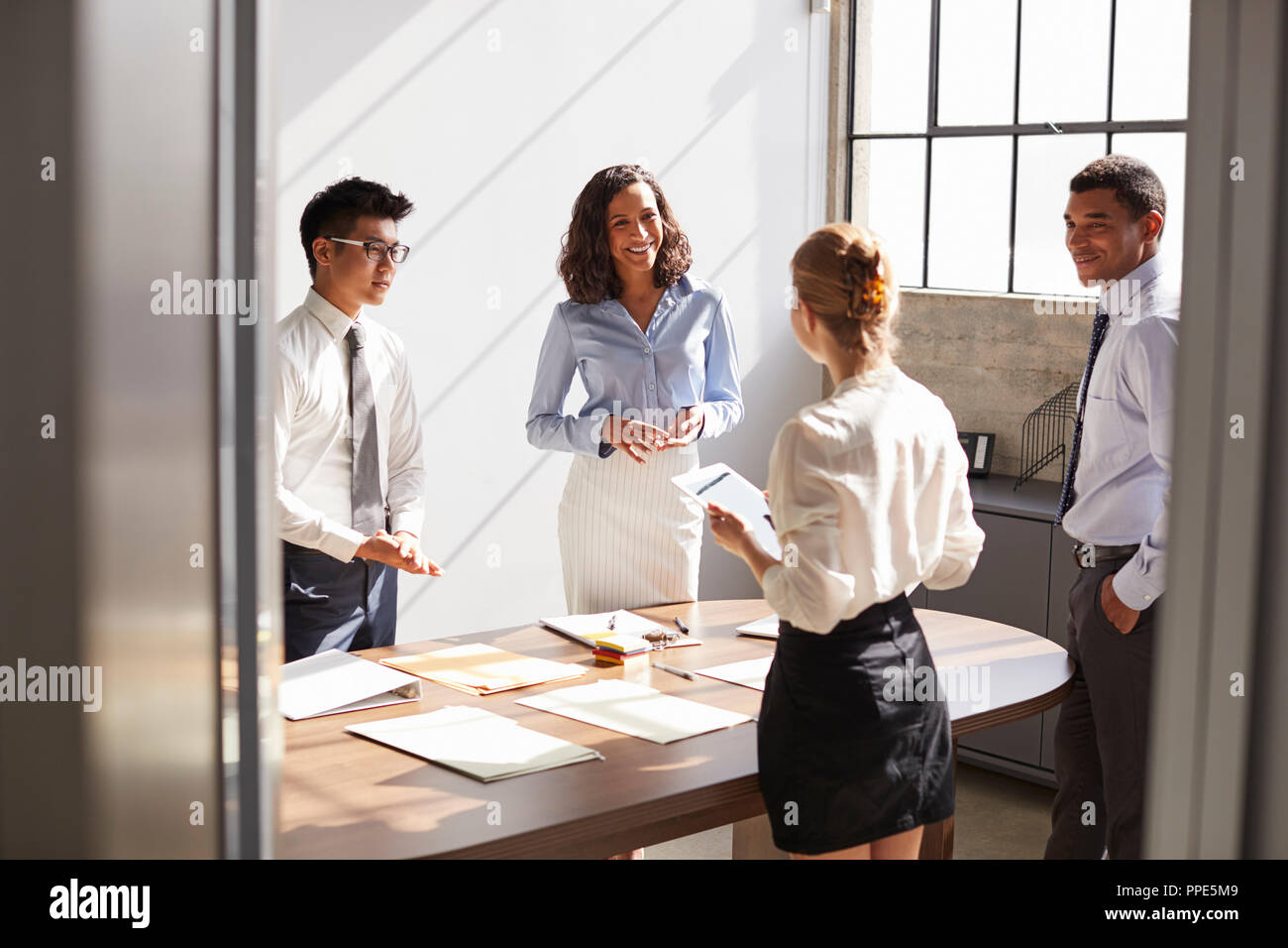 Four business colleagues working together in a small office Stock Photo