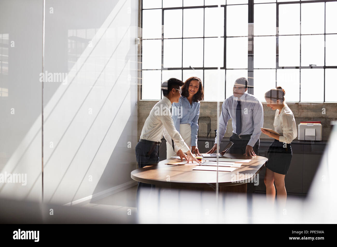 Business team seen through window working together in office Stock Photo