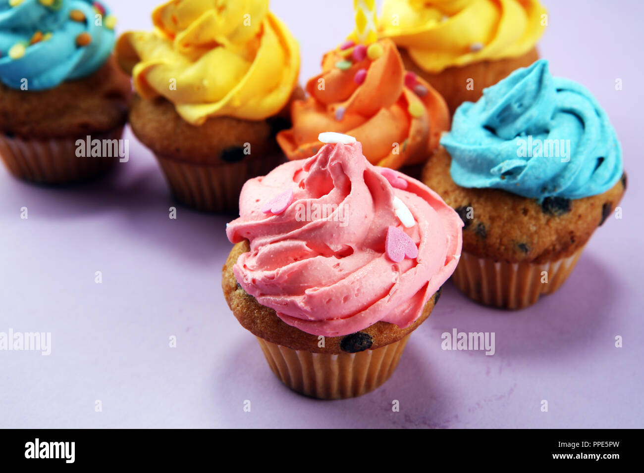Tasty cupcakes on pinke background. Birthday cupcake in rainbow colors Stock Photo