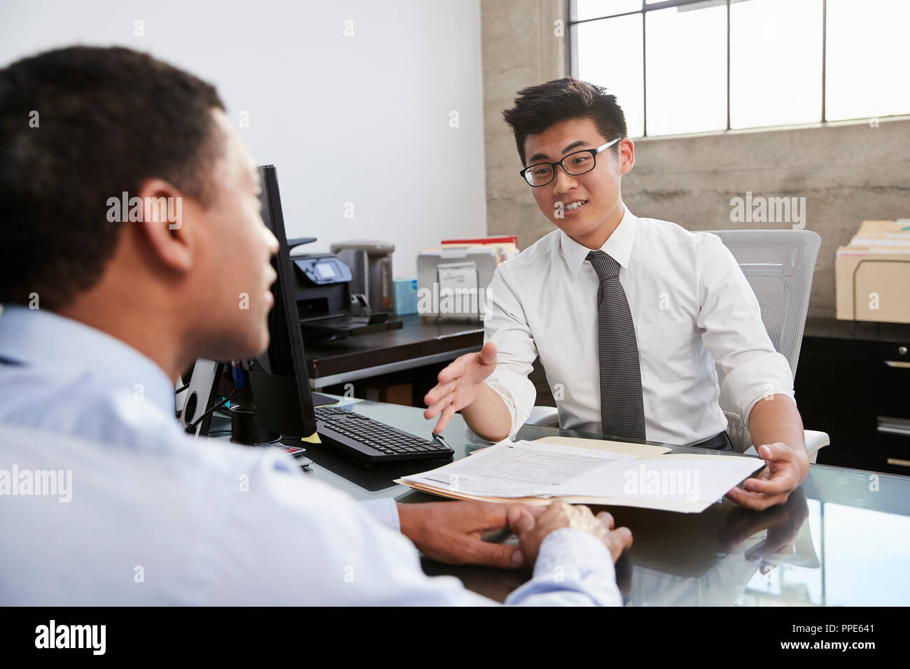 Young Asian professional in meeting with mixed race man Stock Photo