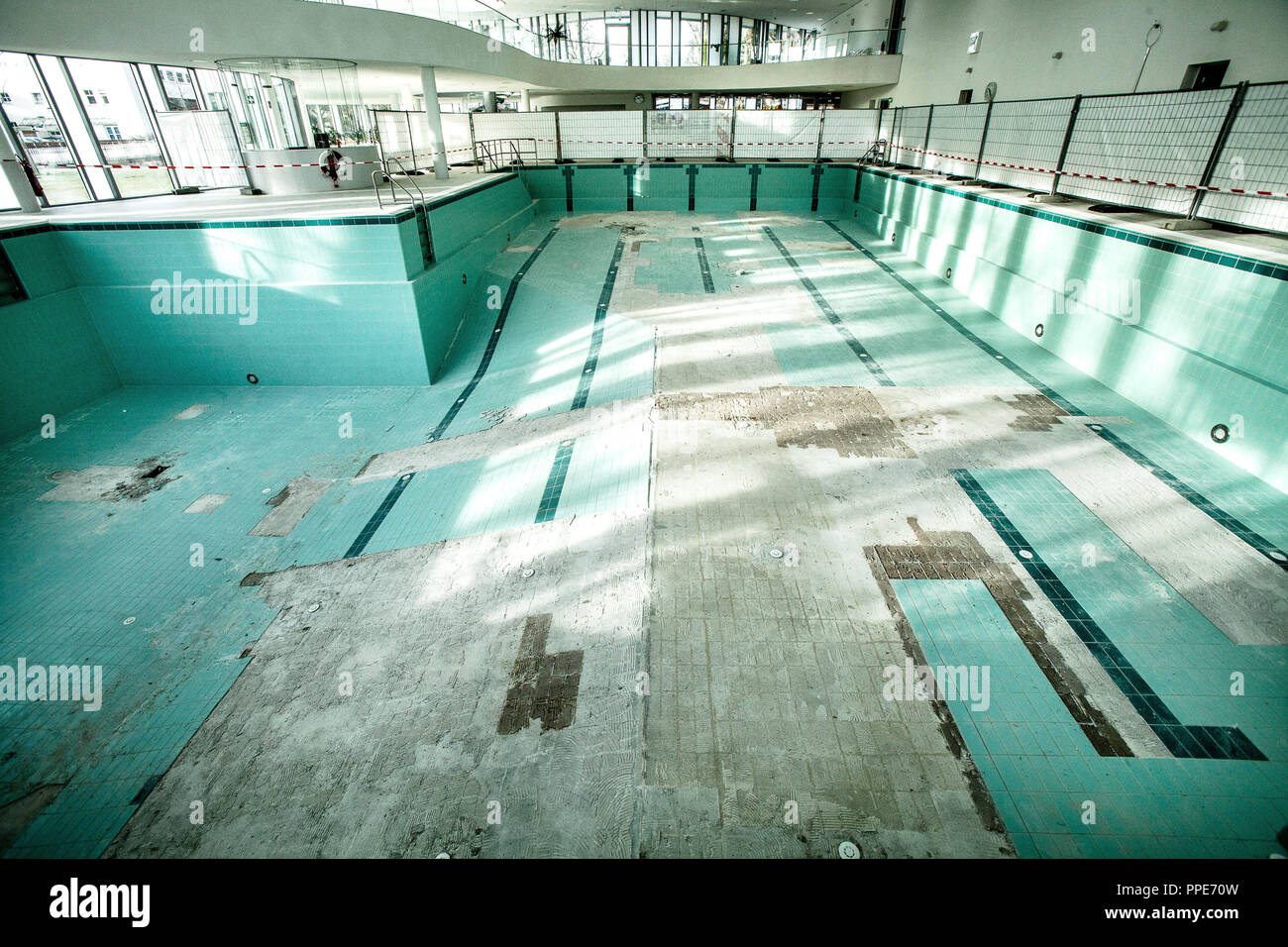 In the renovation-requiring indoor swimming pool in Ismaning, tiles are detached from the floor of the large swimming pool. Stock Photo