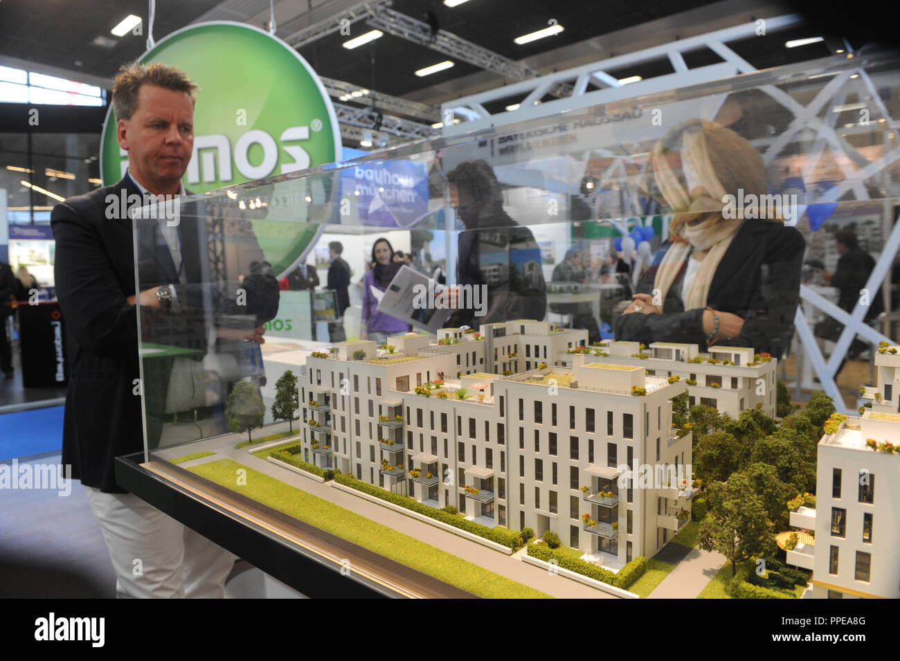 Visitors look at the model of a housing complex at the Real Estate Fair in Munich. Stock Photo
