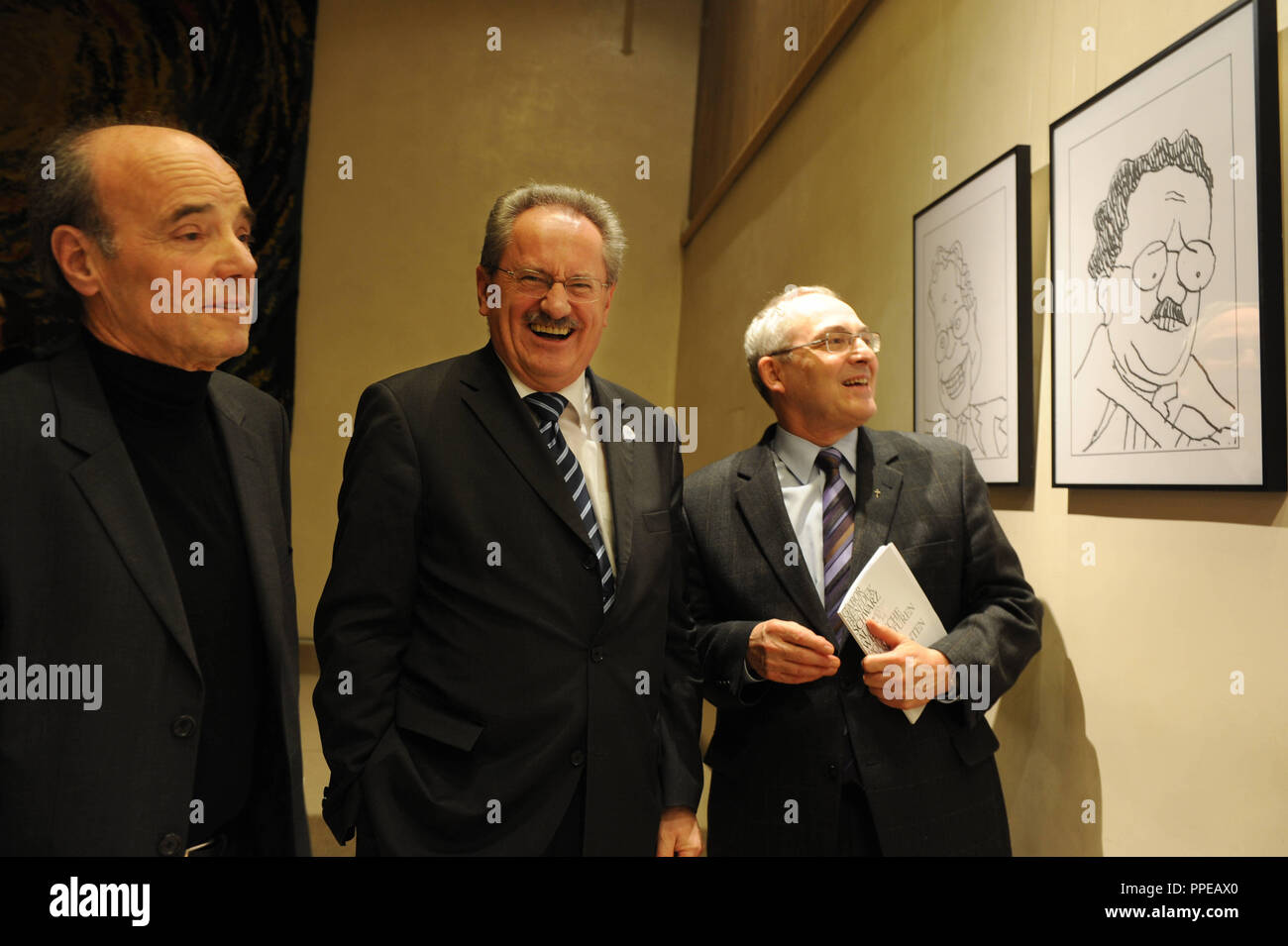 Left to right: Gabor Benedek, political cartoonist for Sueddeutsche Zeitung, Christian Ude, the mayor of Munich and Academy Director Dr. Florian Schuller at the opening of an exhibition of Benedek's cartoons in the Catholic Academy of Bavaria. Stock Photo