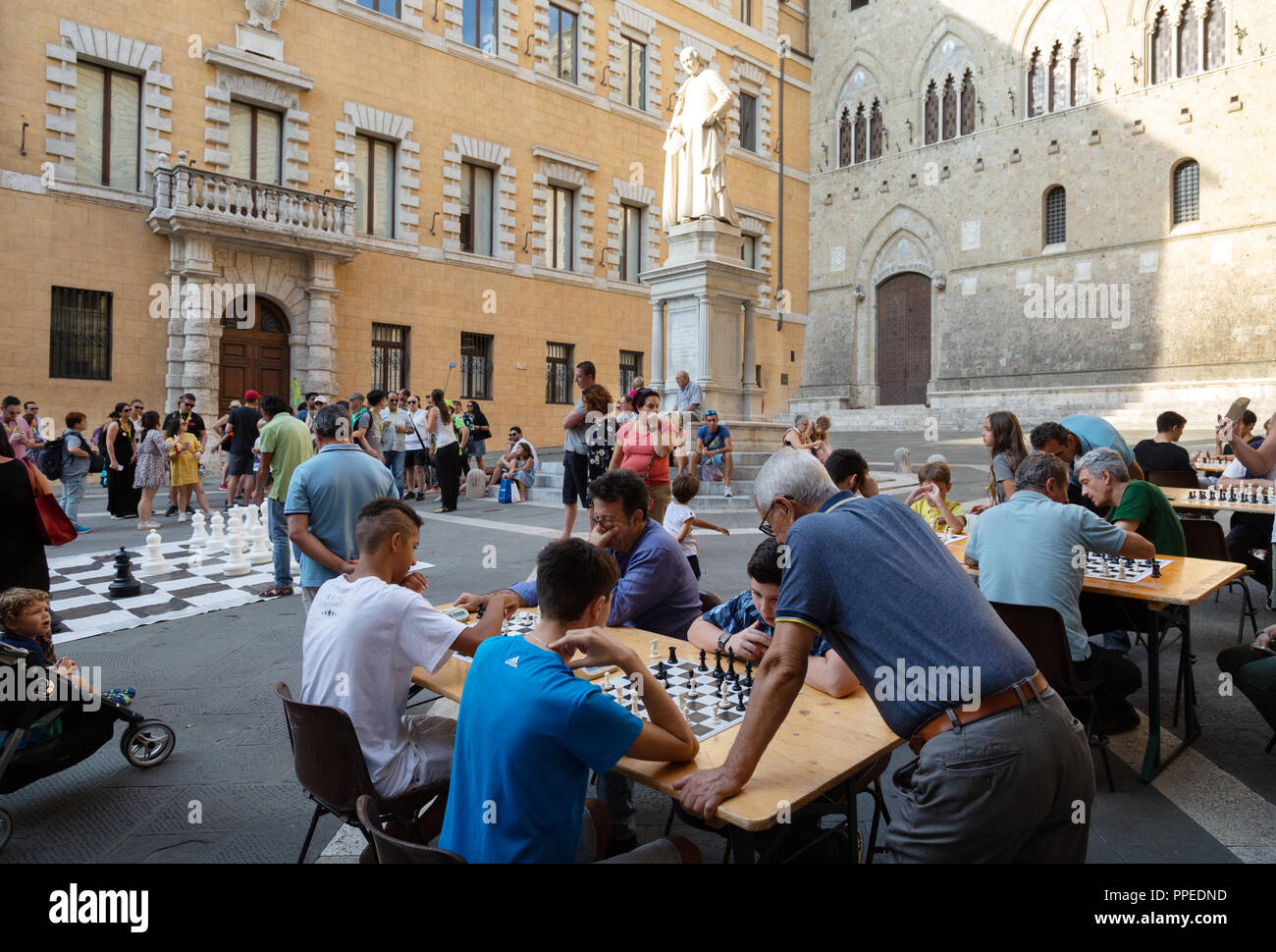 People playing outdoor chess, Piazza Salimbeni, Siena, Tuscany Italy Europe Stock Photo