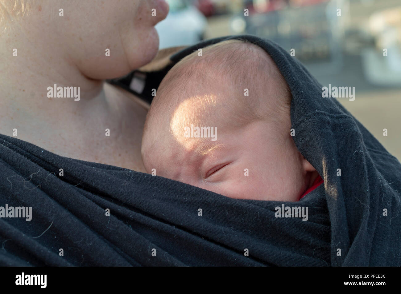 Wheat Ridge, Colorado - A young mother with her sleeping infant. Stock Photo