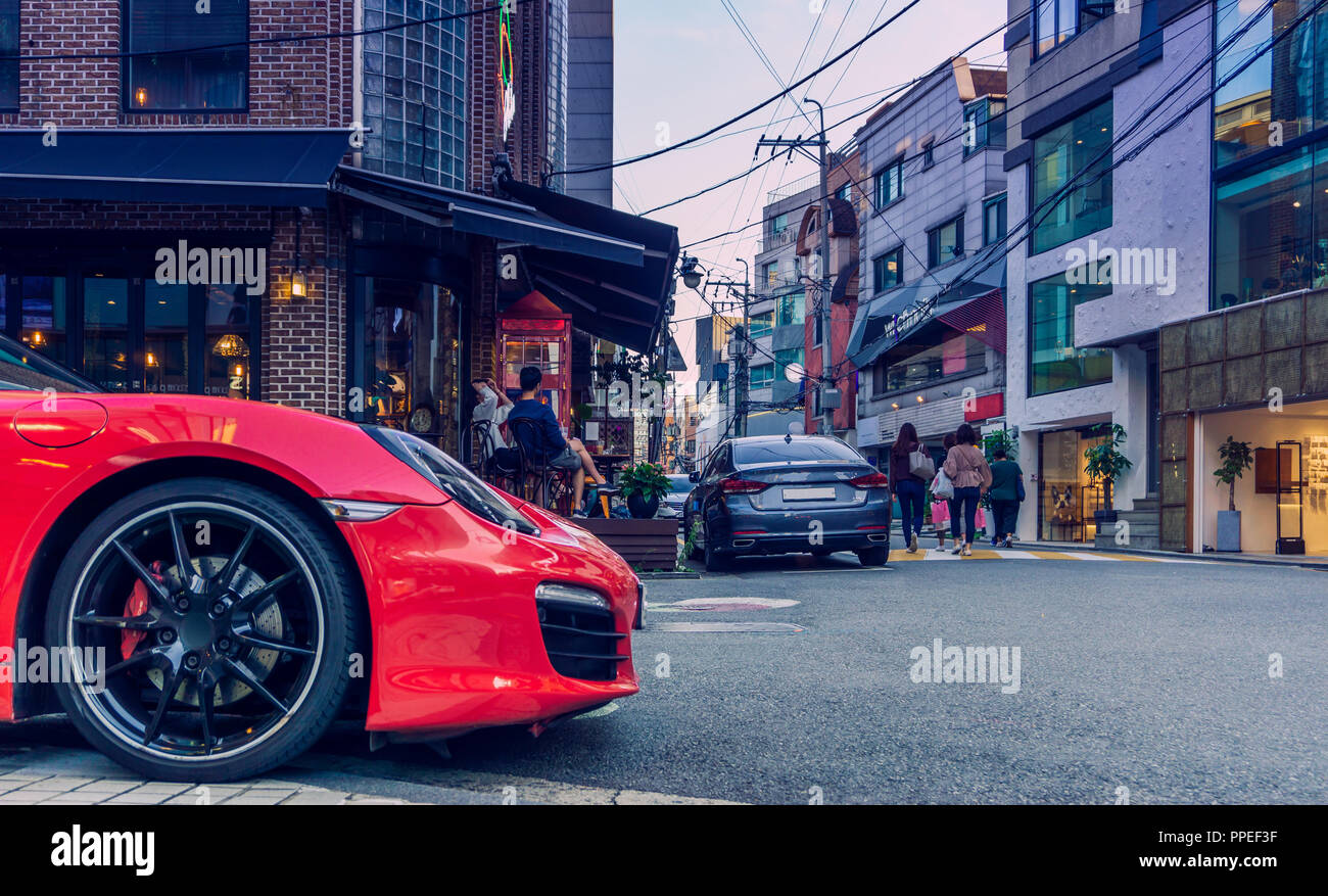 A red shiny Porsche at the backstreet of Garosu-gil where the hip place of Gangnam, Seoul. There are famous restaurant, cafe, and boutique. Stock Photo