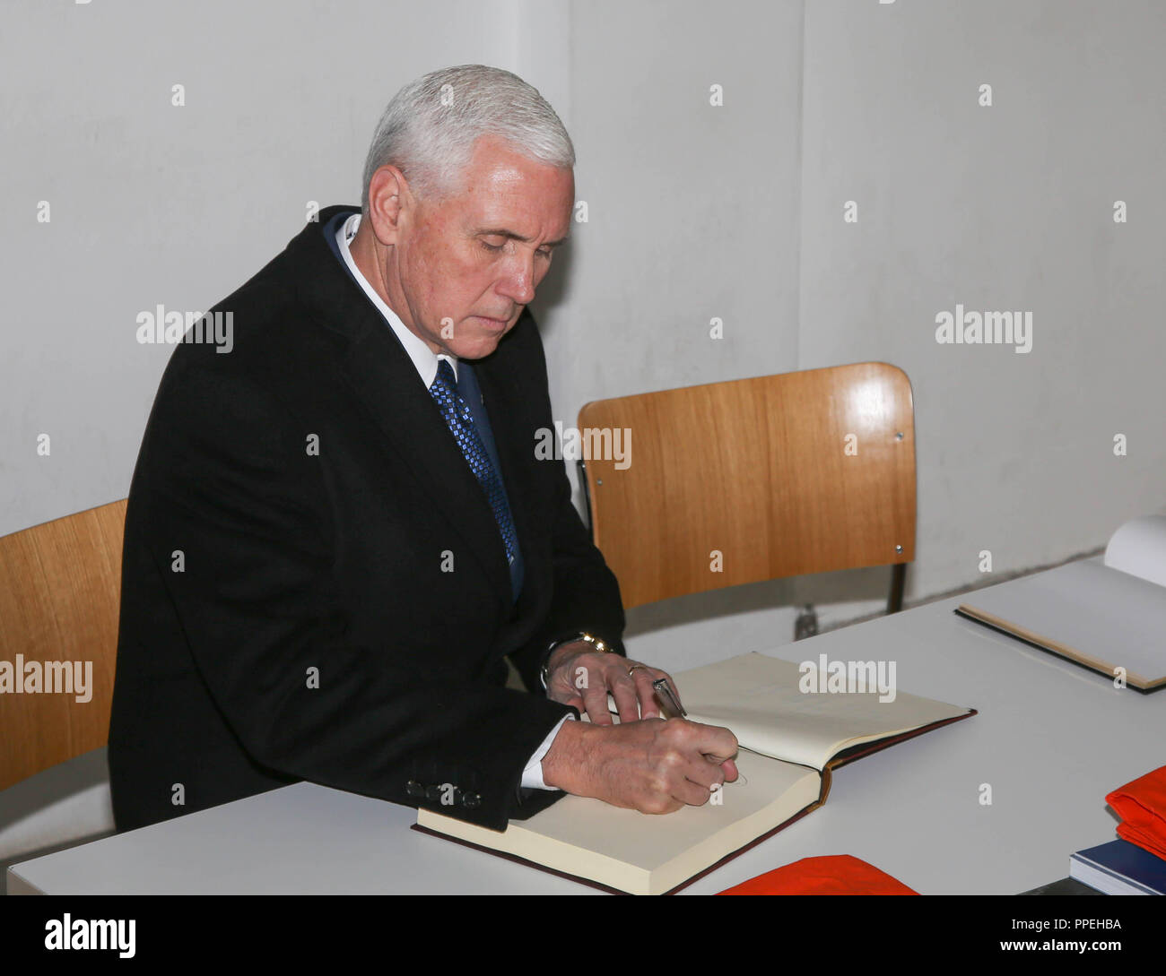 The US Vice President, Mike Pence, signs the guestbook of the museum during his visit to the Dachau Concentration Camp Memorial Site. Stock Photo