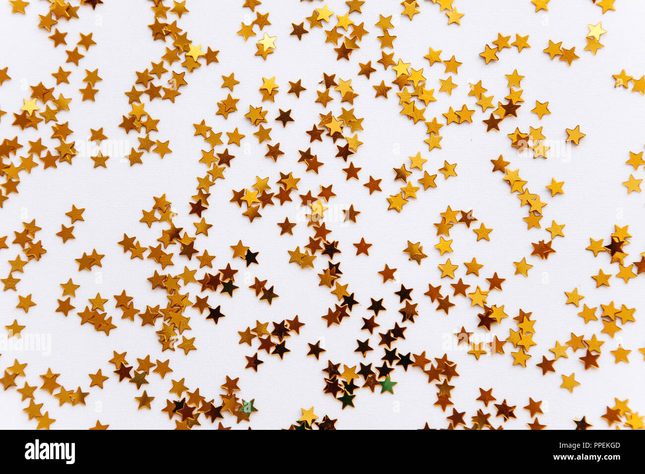 Festive golden stars of confetti on a white background Stock Photo - Alamy