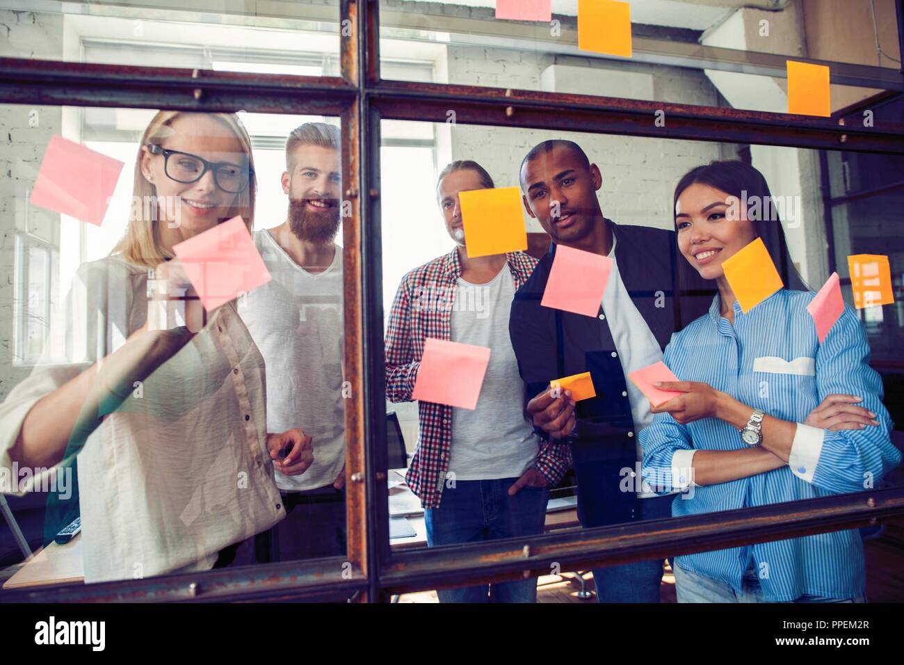 Business people meeting at office and use post it notes to share idea. Brainstorming concept. Sticky note on glass wall Stock Photo