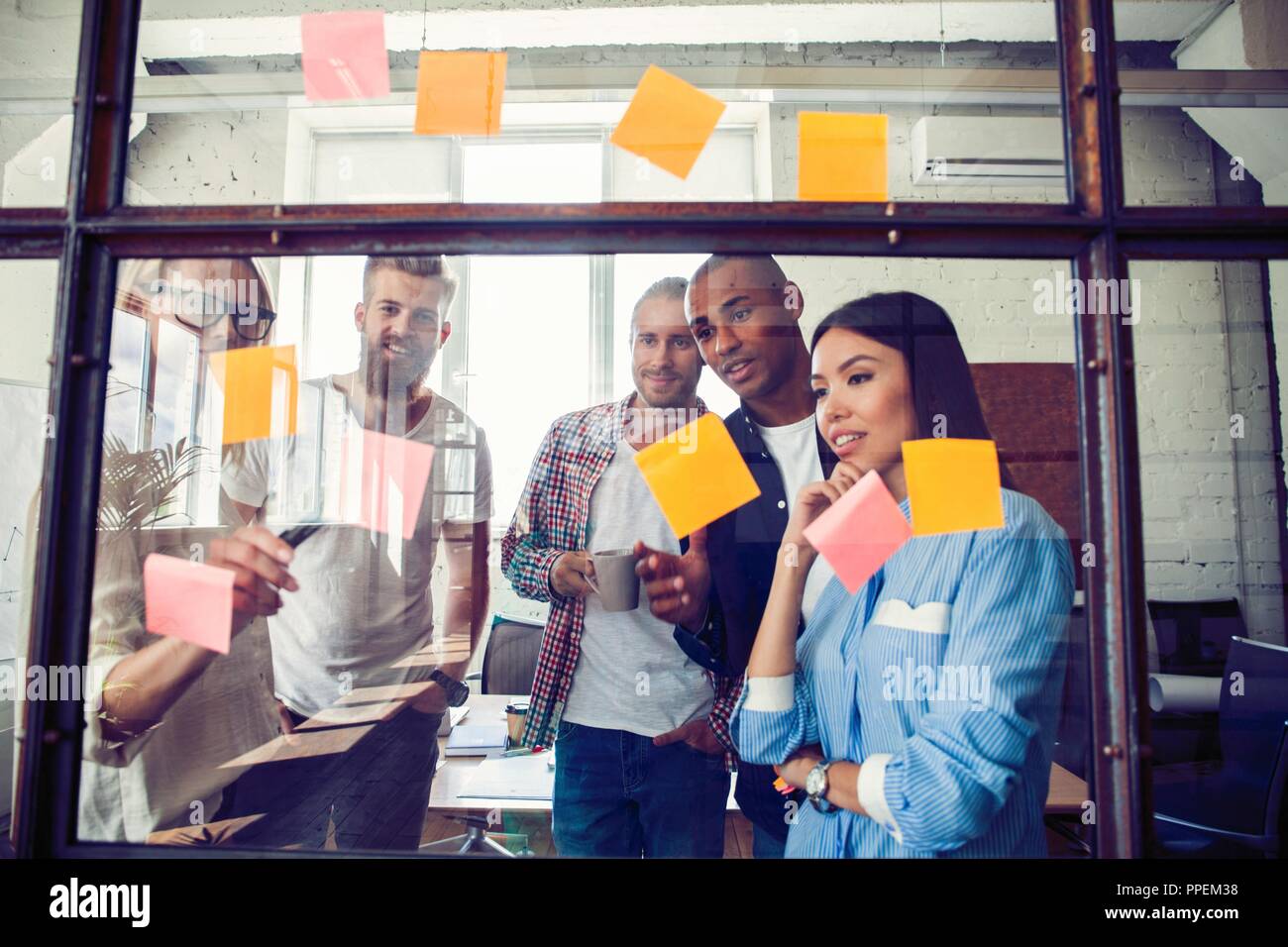 Business people meeting at office and use post it notes to share idea. Brainstorming concept. Sticky note on glass wall Stock Photo