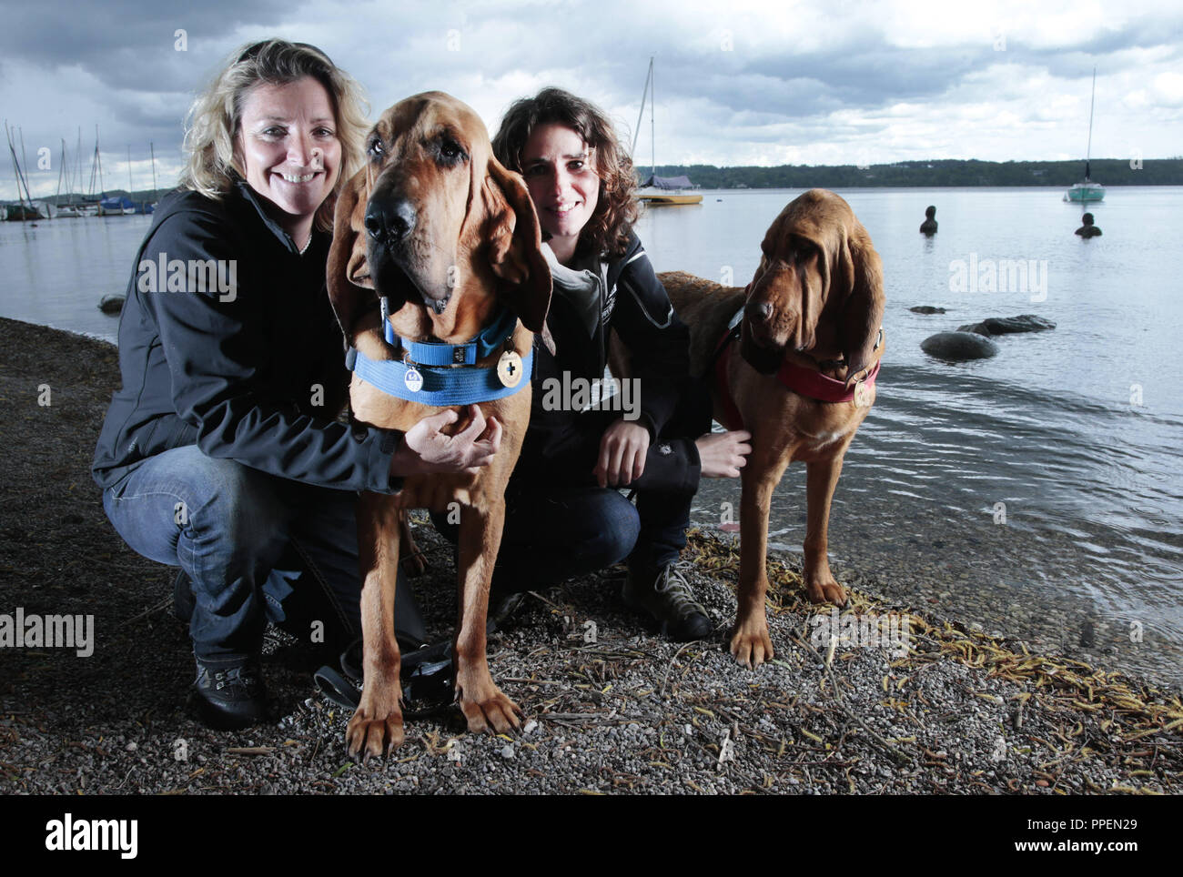 Dog trainers Alexandra Grunow (left) and Rovena Langkau with two of their search dogs in Schondorf am Ammersee. Stock Photo