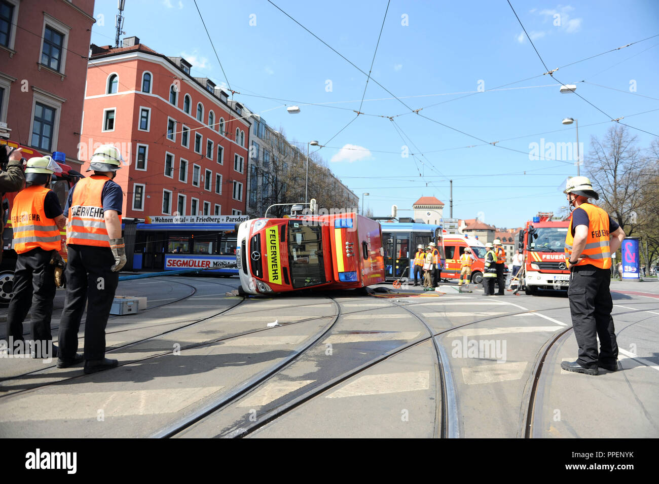 An overturned ambulance van of the Munich Fire Department is put back on its wheels after hitting a streetcar on the line 18 at the intersection Zweibrueckenstrasse and Thierschstrasse. Stock Photo