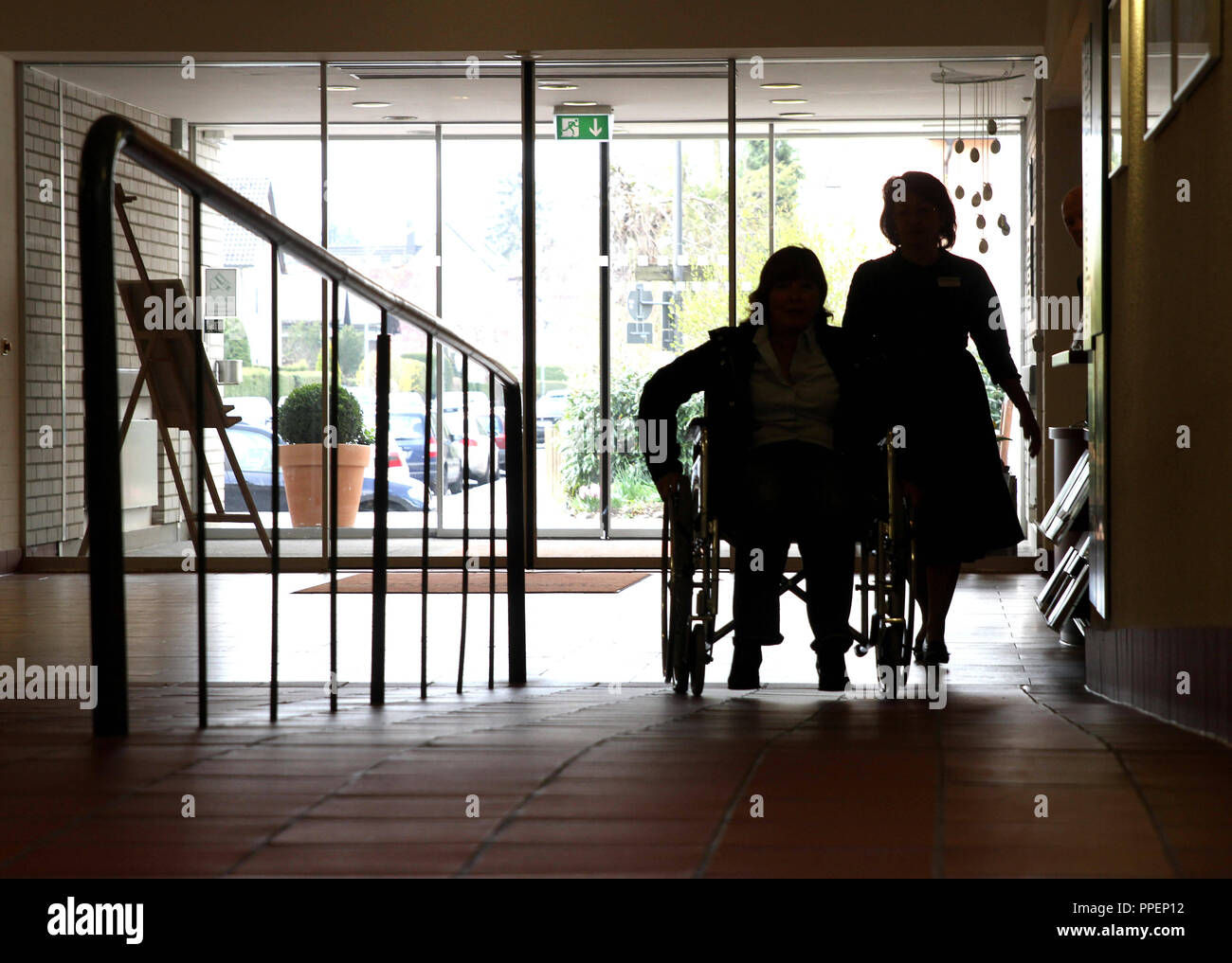 Senior Woman In Wheelchair On The Ramp At The Entrance Of The