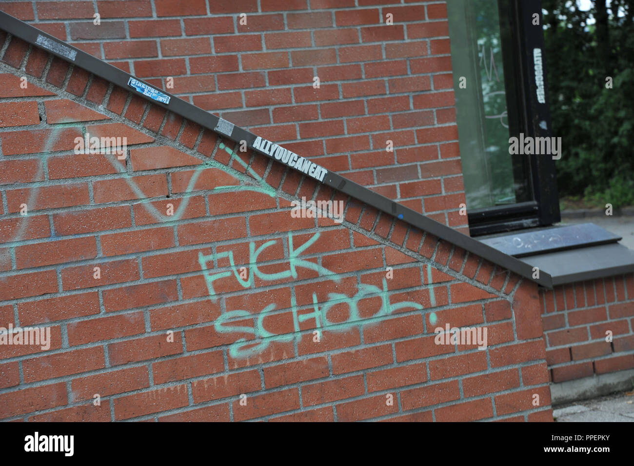 Graffiti on a brick wall of the Erasmus Grasser-Gymnasium in Munich, Germany Stock Photo