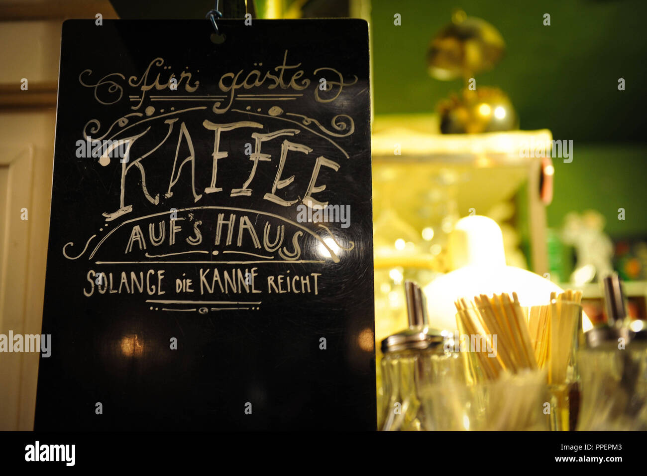Free coffee for guests ' is written on a black table at the bar 'Frida' in the Schwabing district of Munich, Germany Stock Photo
