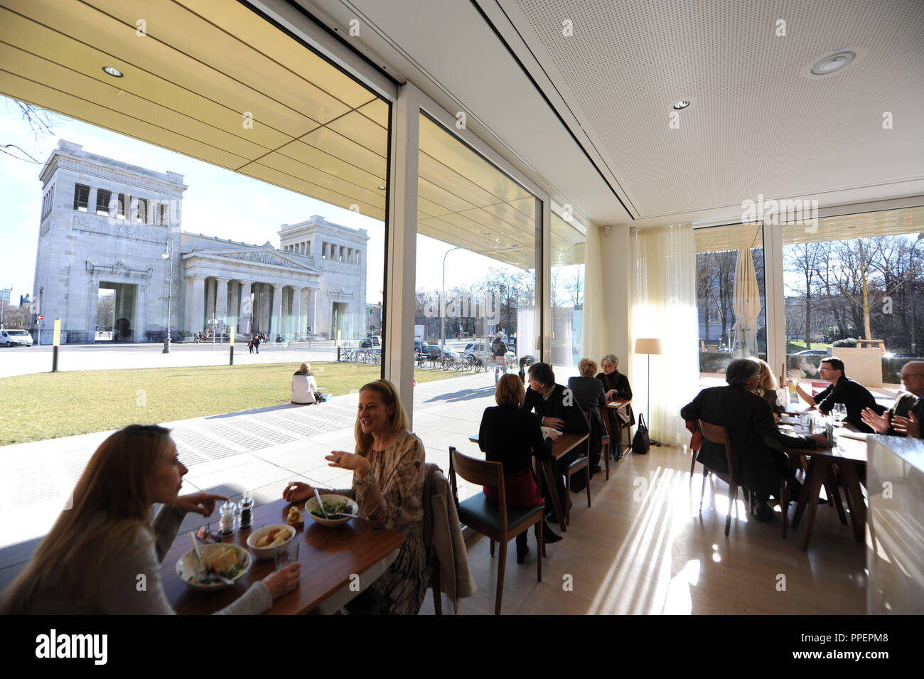 Guests at the restaurant 'Ella' in the Lenbachhaus at Koenigsplatz. In the background, the Propylaea, Munich, Germany Stock Photo