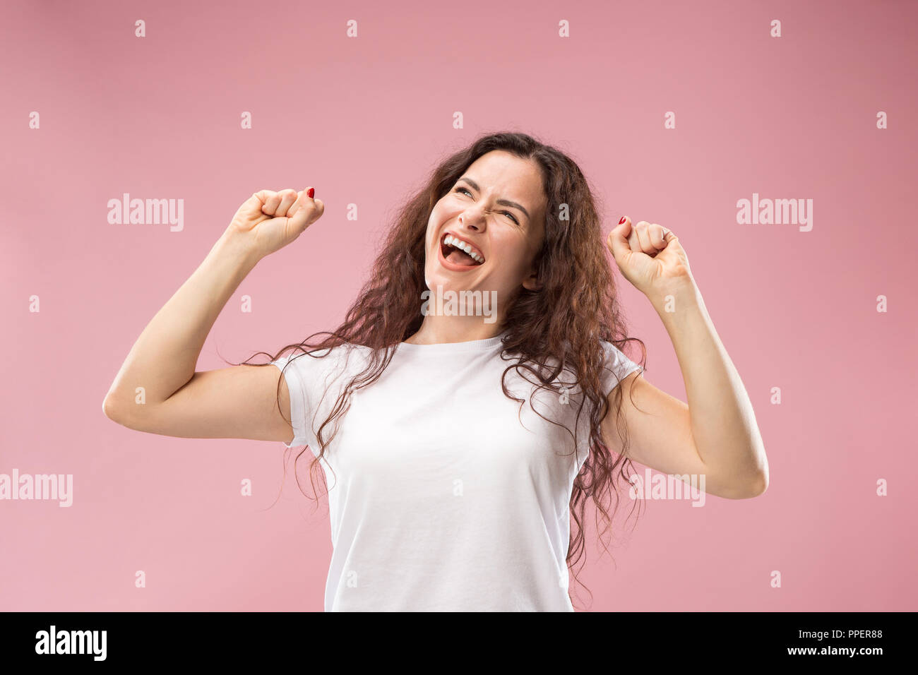 I won. Winning success happy woman celebrating being a winner. Dynamic image of caucasian female model on pink studio background. Victory, delight concept. Human facial emotions concept. Trendy colors Stock Photo