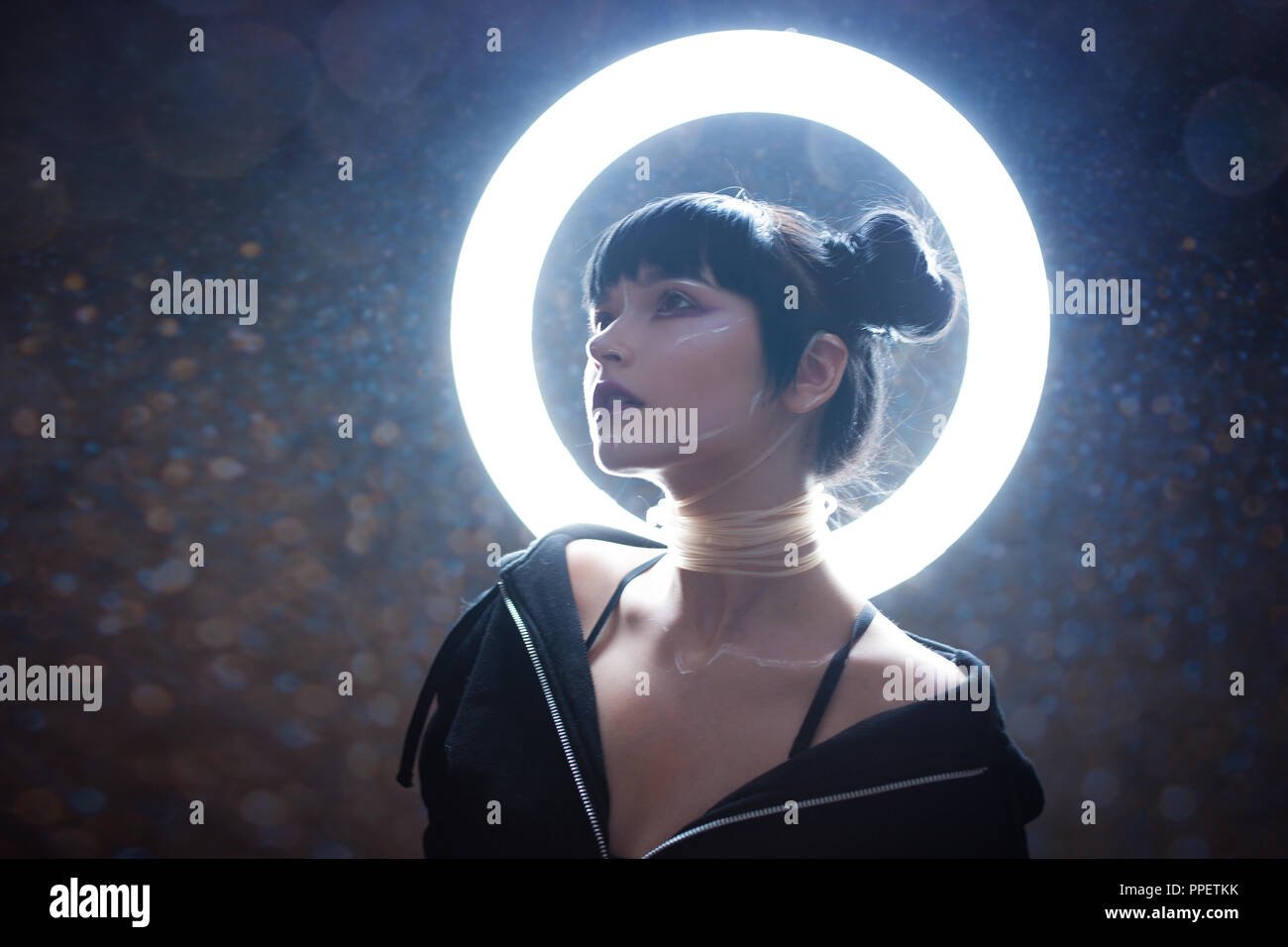 concept of artificial life. Beautiful young woman, futuristic style. Portrait against a glowing circle Stock Photo