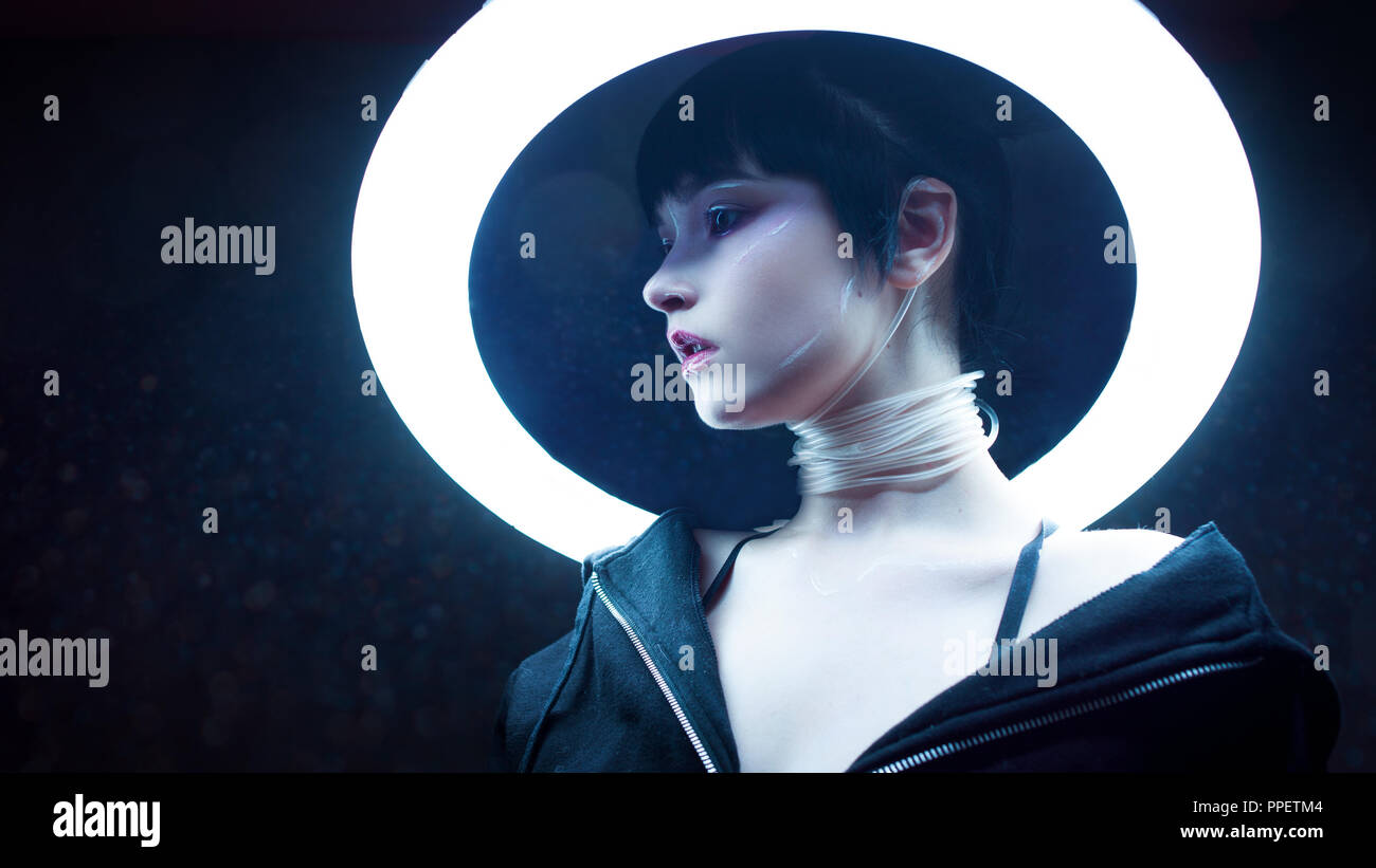 Cyber girl. Beautiful young woman, futuristic style. Portrait against a glowing circle Stock Photo